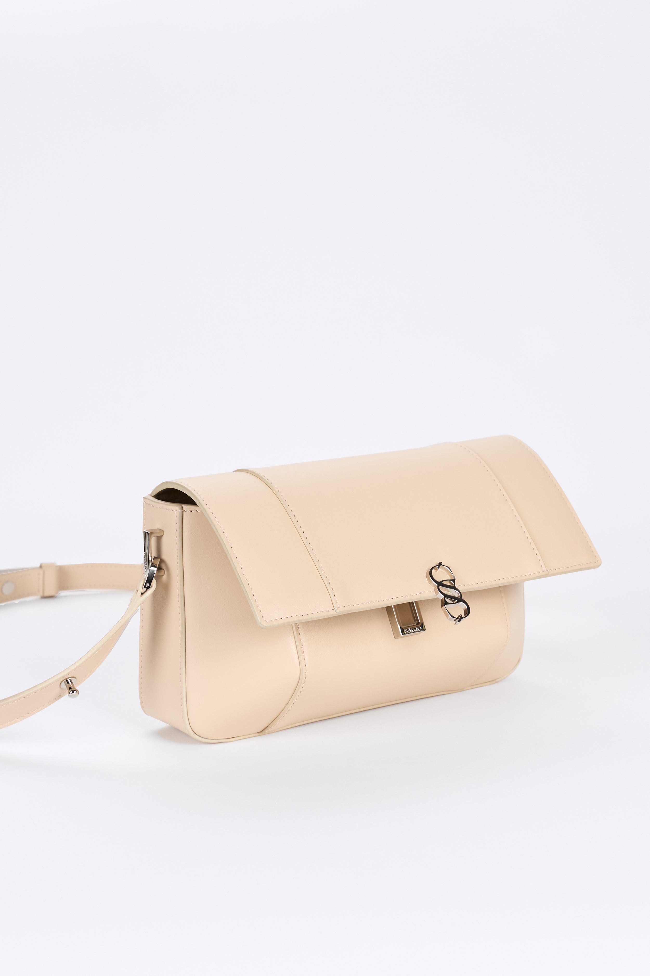 Beige leather bag detail with flap closure and silver-tone hardware