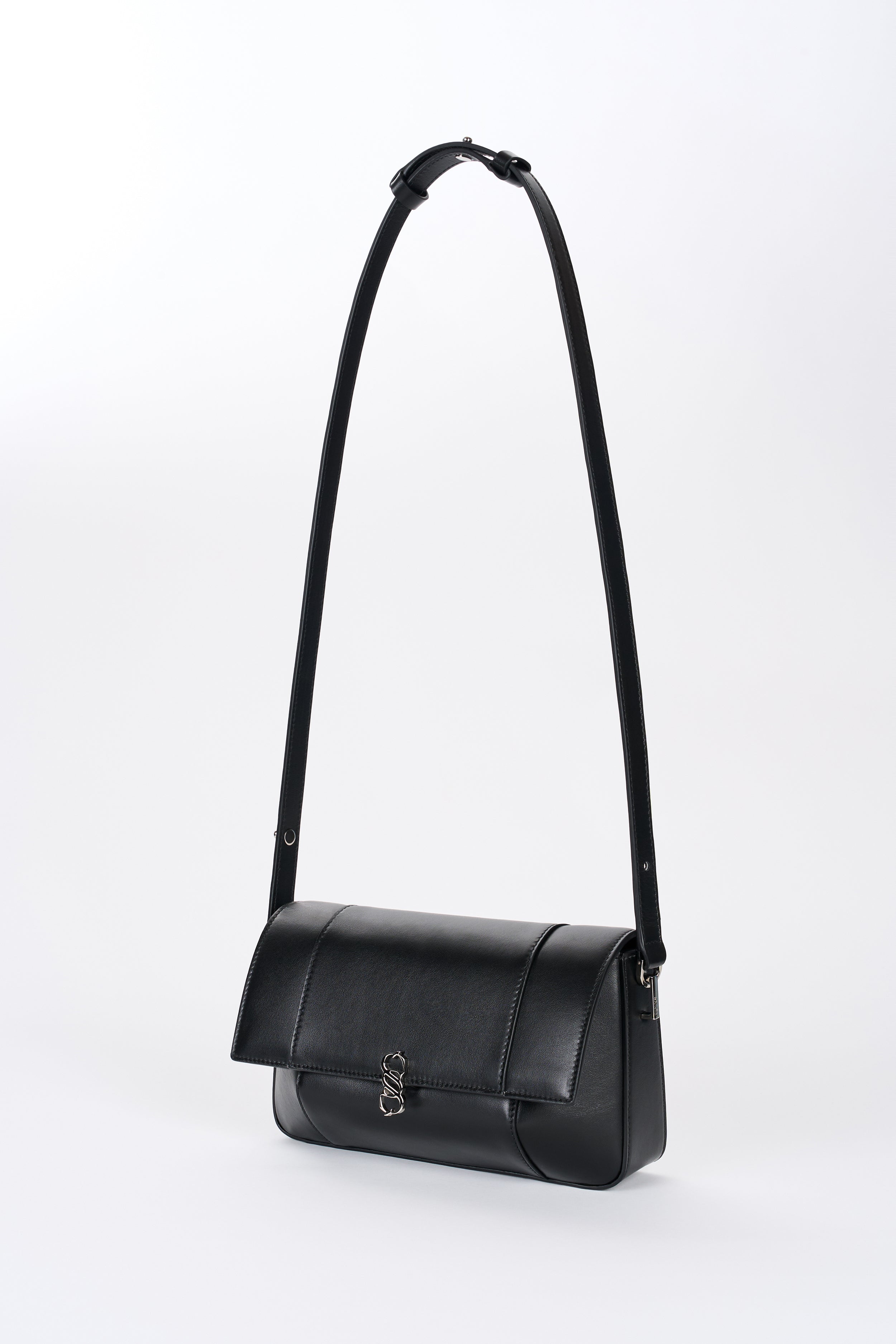 Black Il Cupola bag angled front view with elongated strap and curved flap