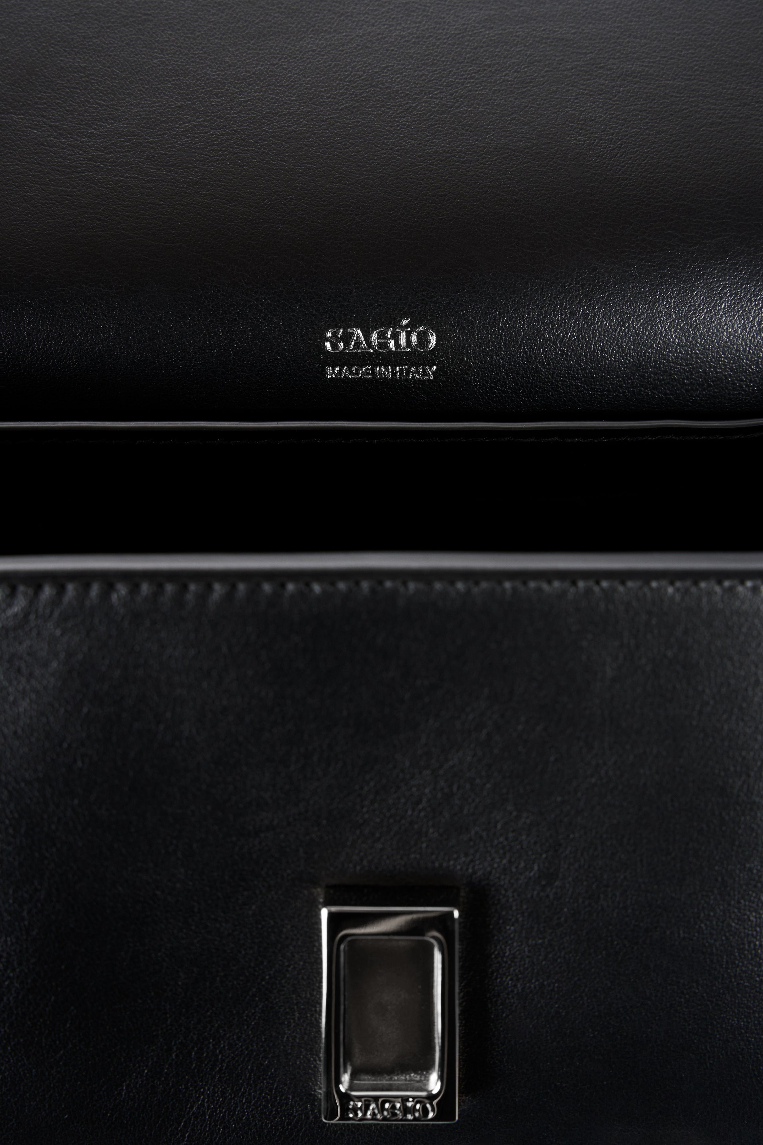 Black Il Cupola bag interior detail with SAGIO logo stamp and silver-tone clasp