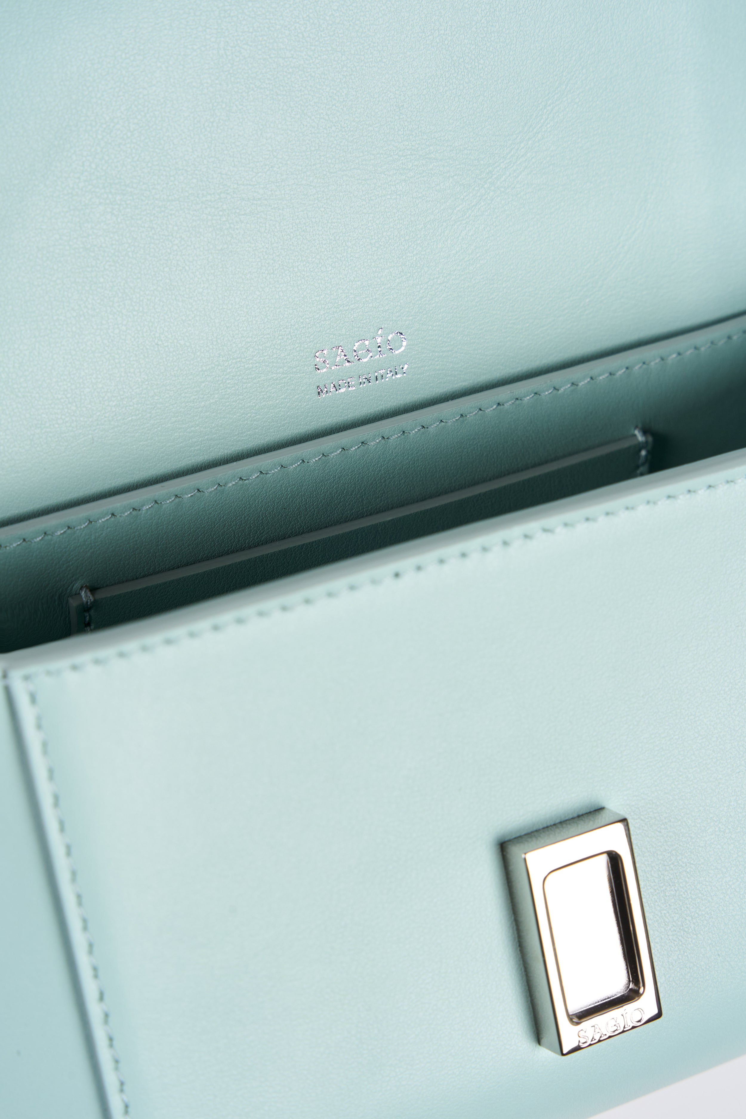 Clear aqua Il Cupola bag interior detail with SAGIO logo stamp and silver-tone clasp