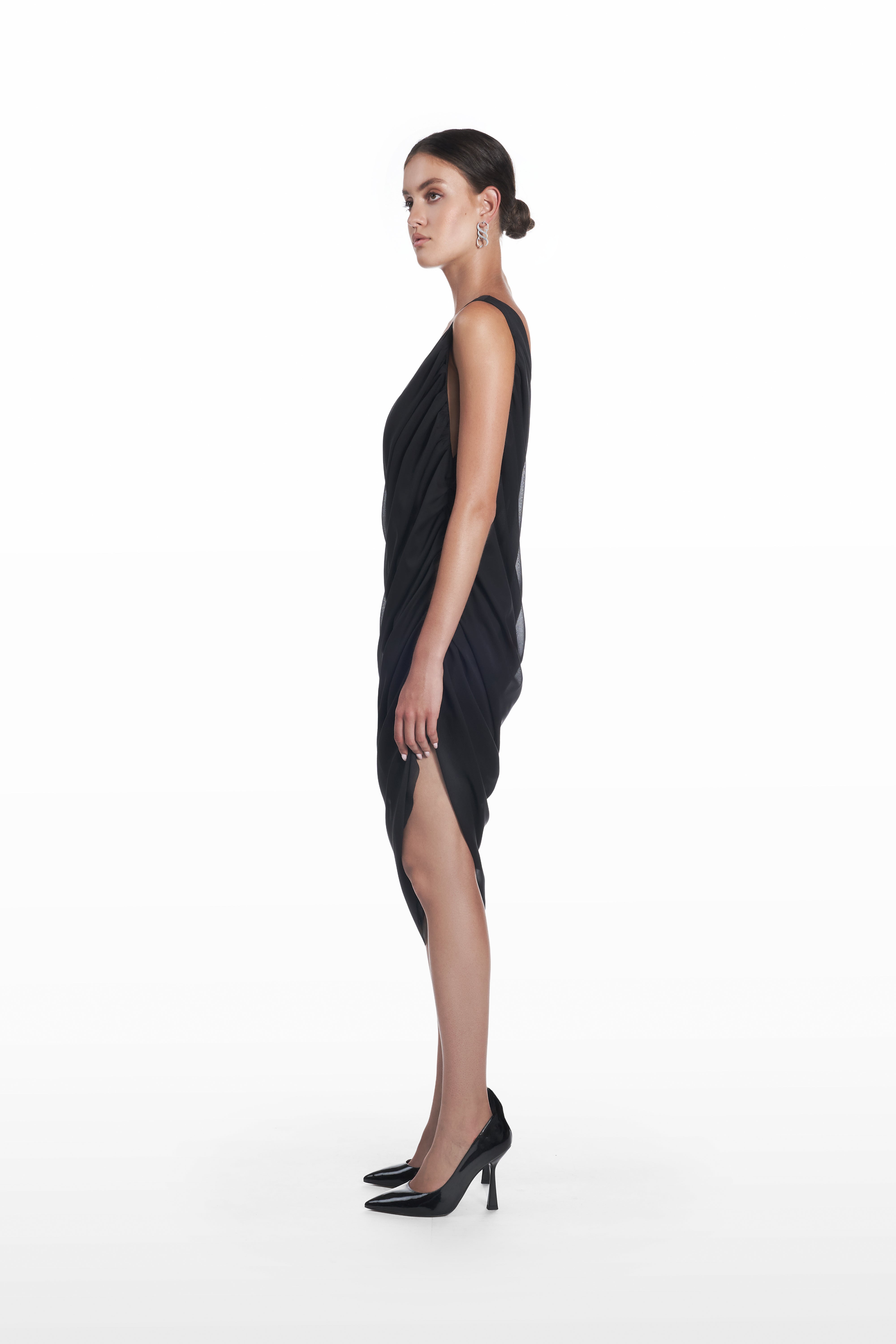 Stola Silk Dress in Black, side view, black sleeveless silk dress with diagonal draping, soft body-skimming shape and asymmetric midi length