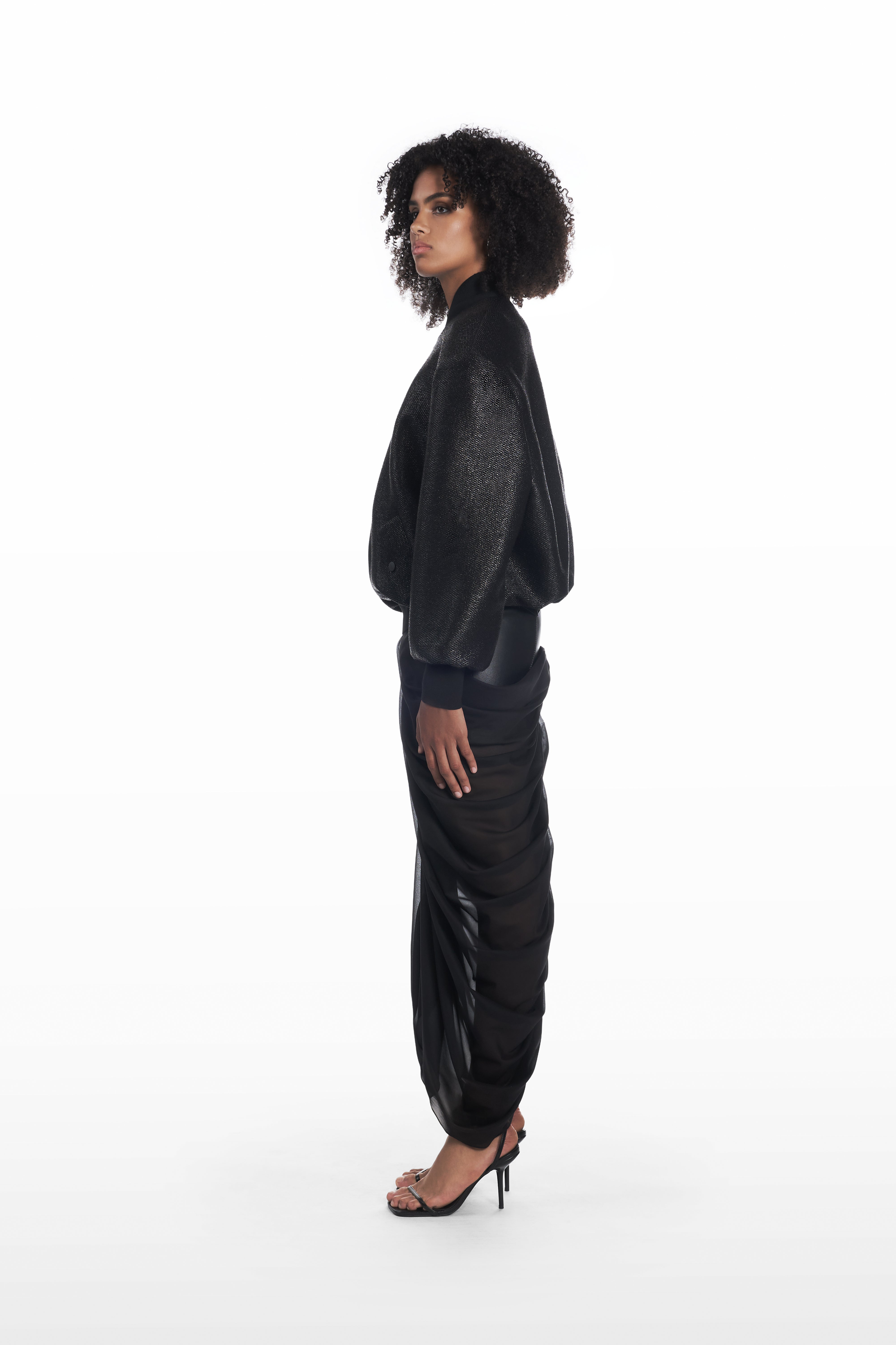 Oversize Raffia Bomber in black, side view with rounded volume and tactile raffia texture