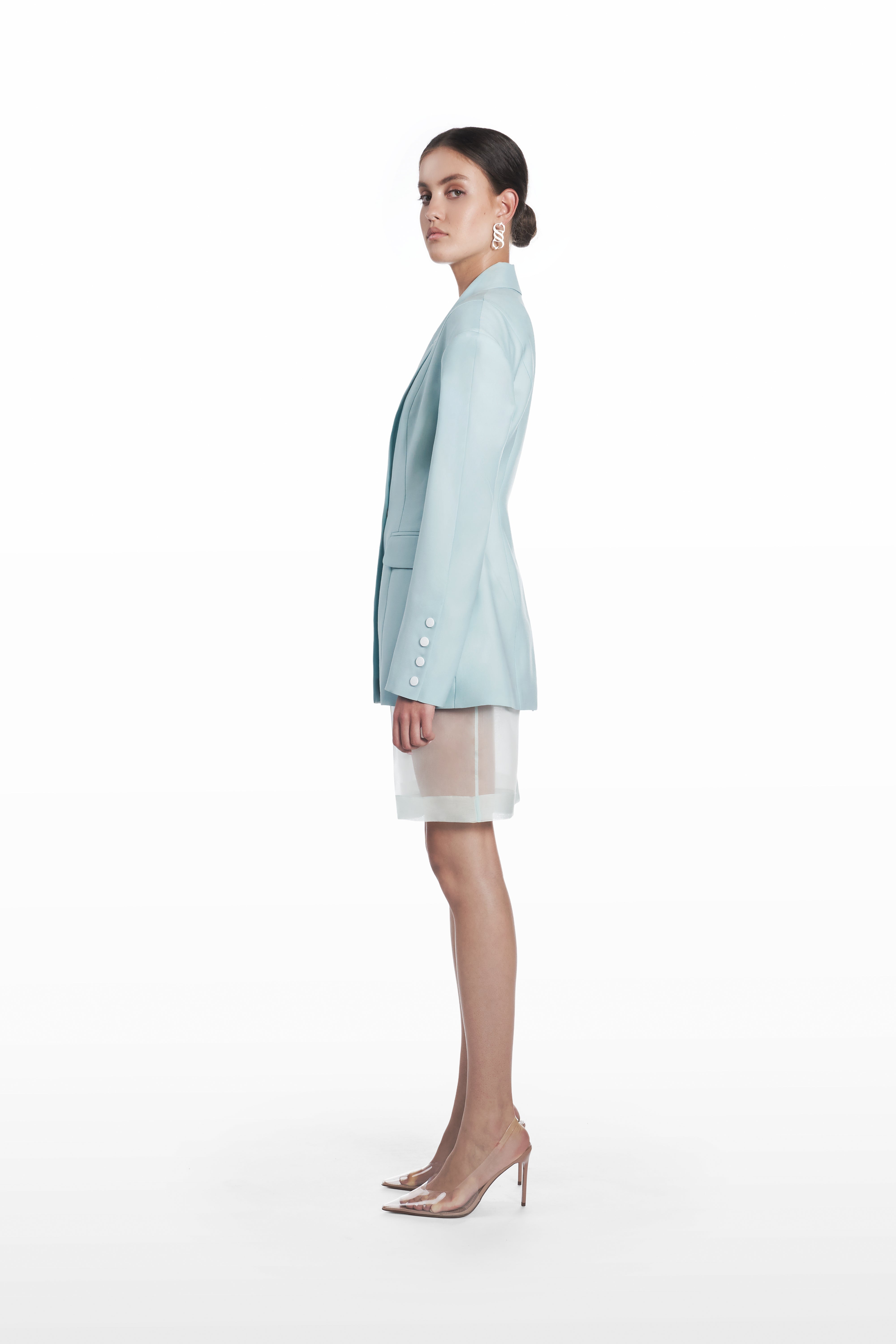 Transparent silk bermuda shorts in clear aqua, side view with fluid bermuda-length silhouette