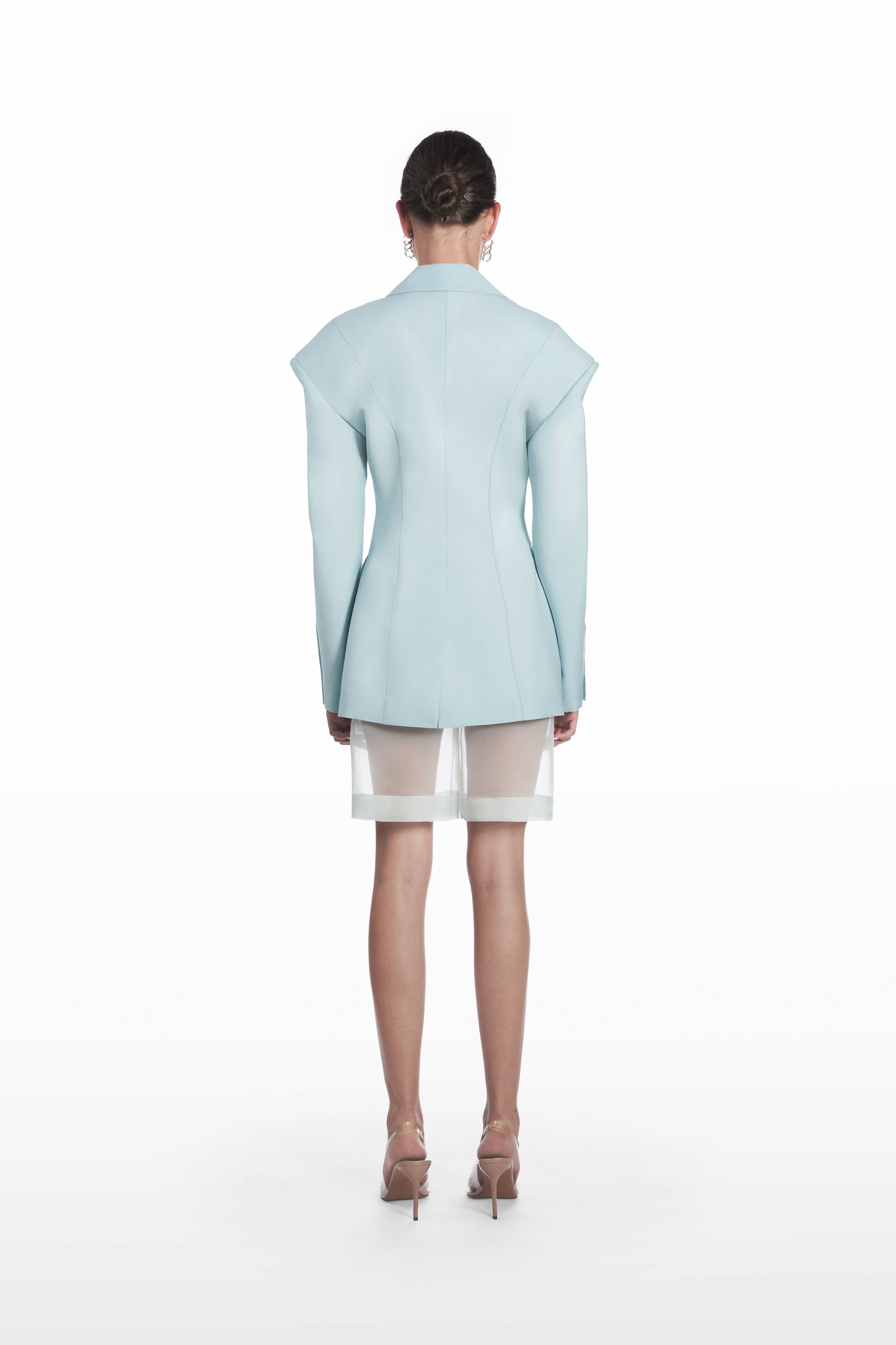 Transparent silk bermuda shorts in clear aqua, back view with sheer construction and clean tailored line