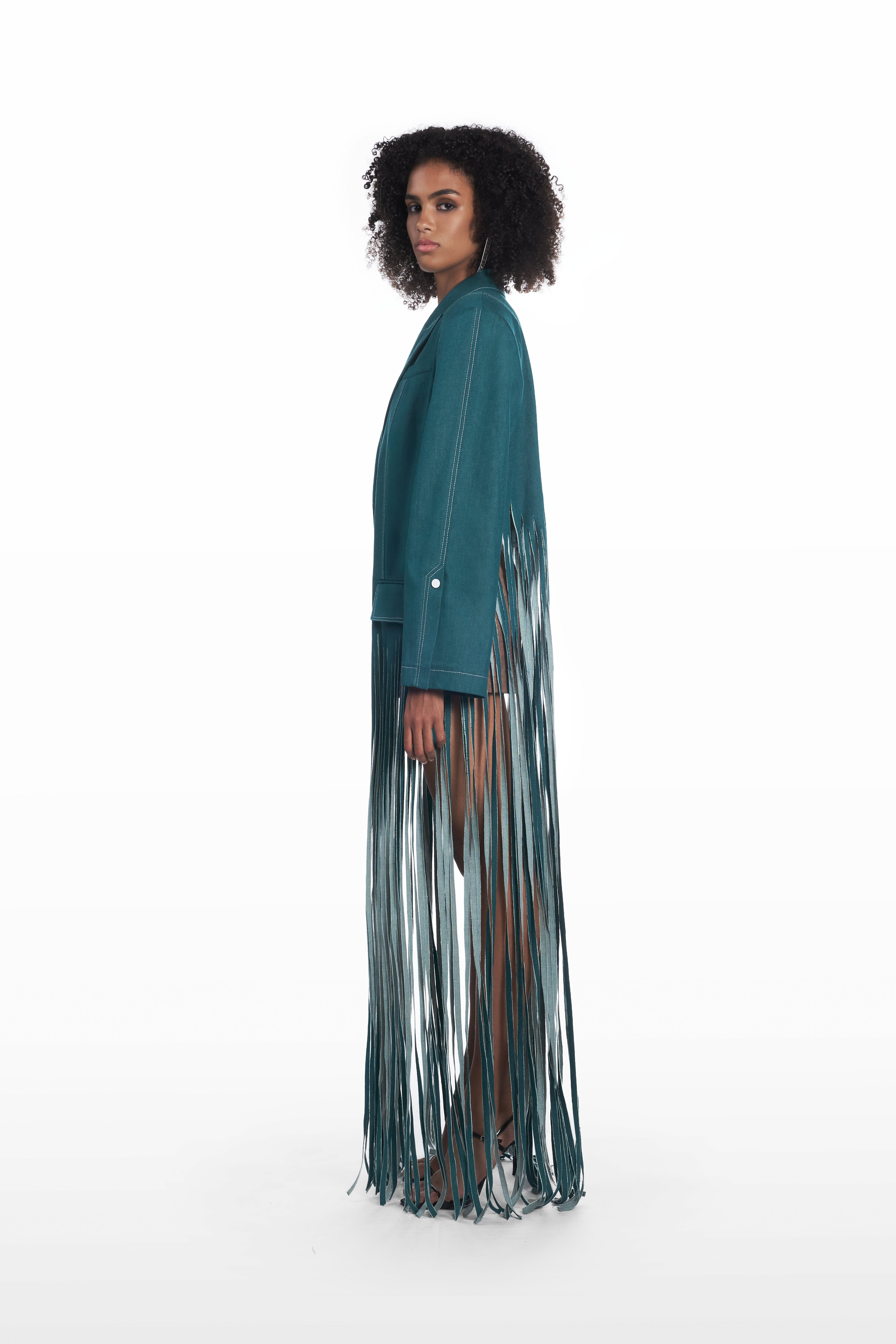 Oversize fringe denim coat in teal, side view with elongated fringe detailing and structured shoulders