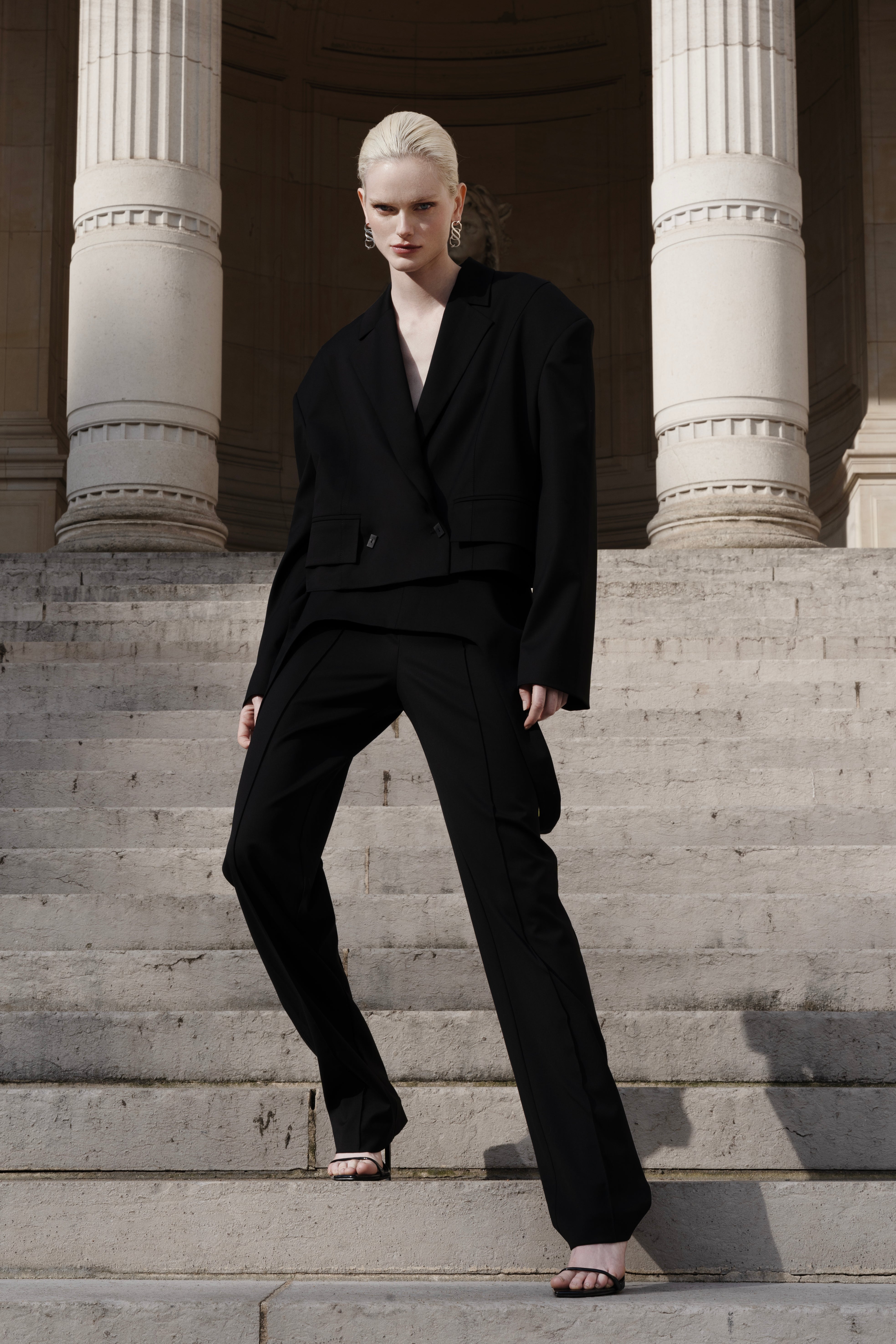 Women’s black wool cropped blazer with falling-shoulder design and sharp lapel