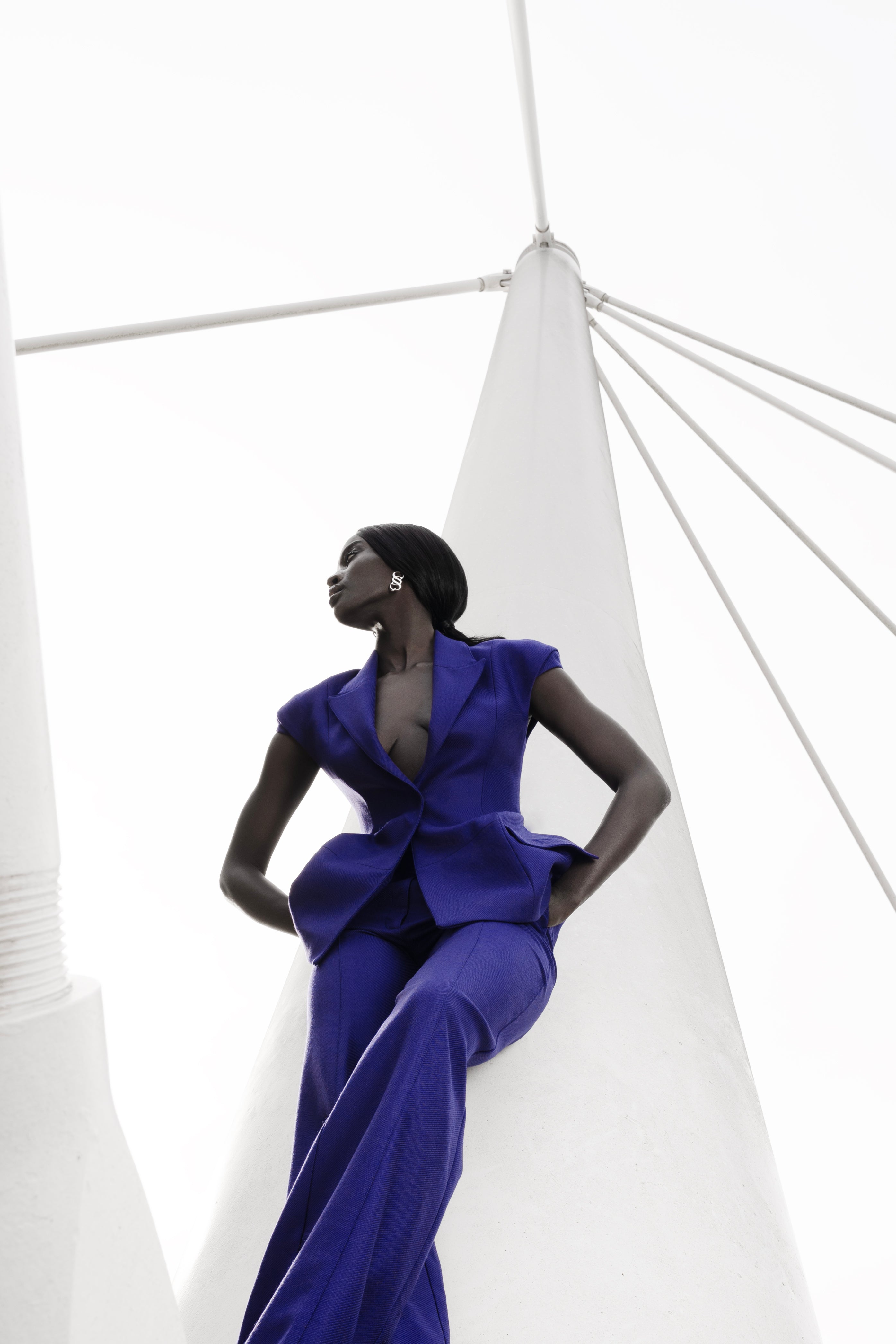 Model in Future Dusk tailored wool trousers and matching blazer under architectural structure