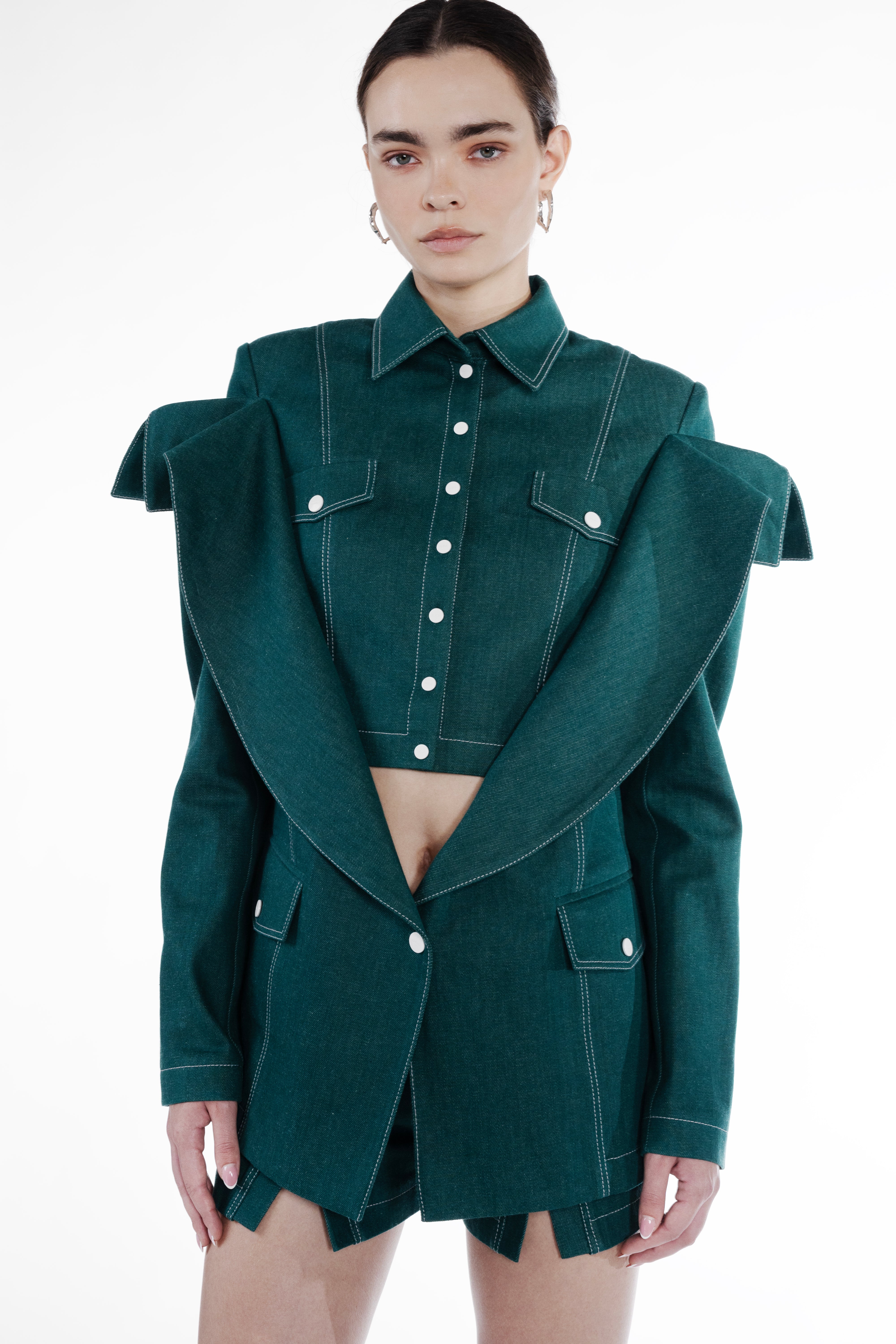 Short Falling Jacket in emerald green cotton, close-up front view, falling shoulder construction, contrast topstitching, and flap pockets