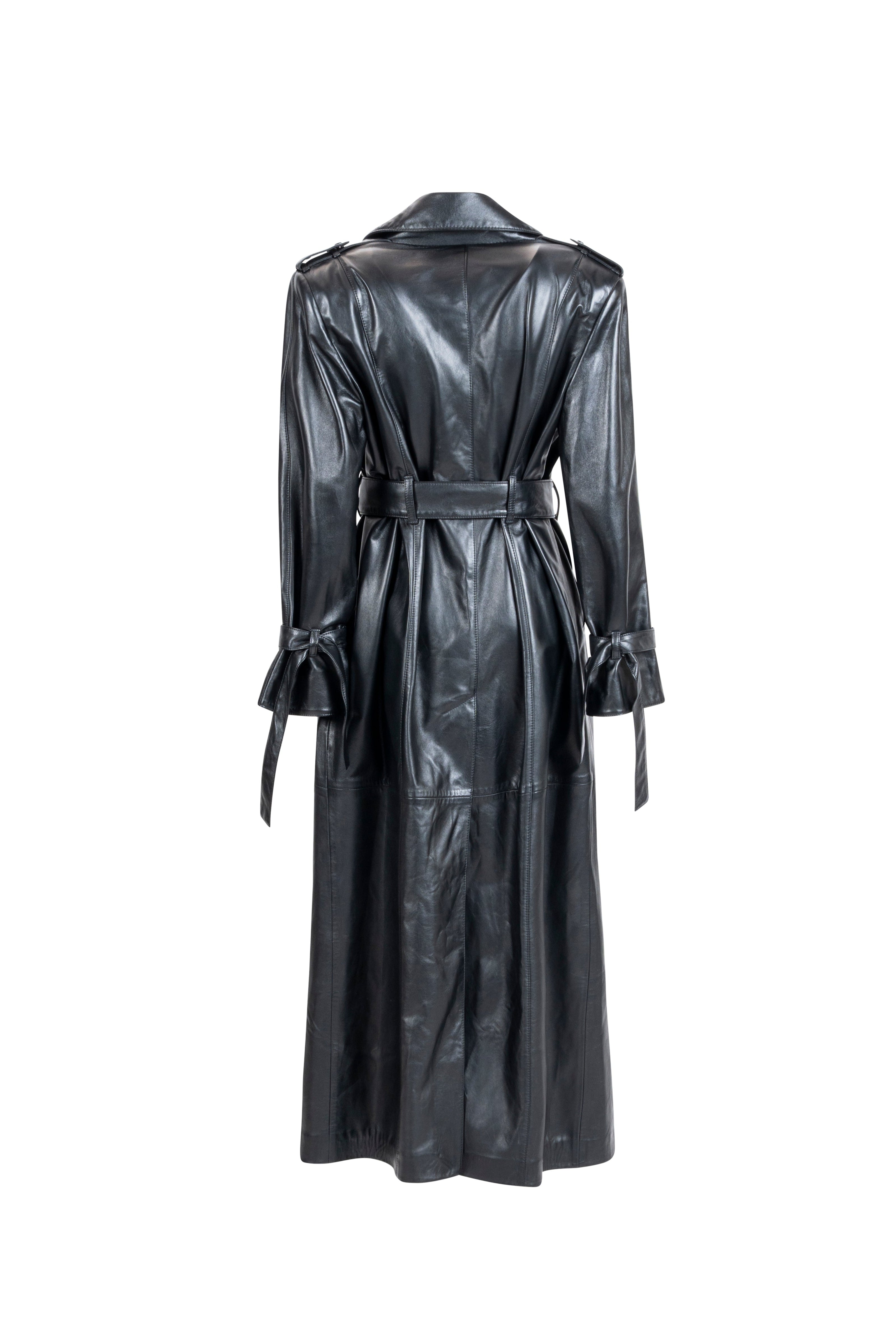 Long black leather trench with waist belt and cuff ties. Back view