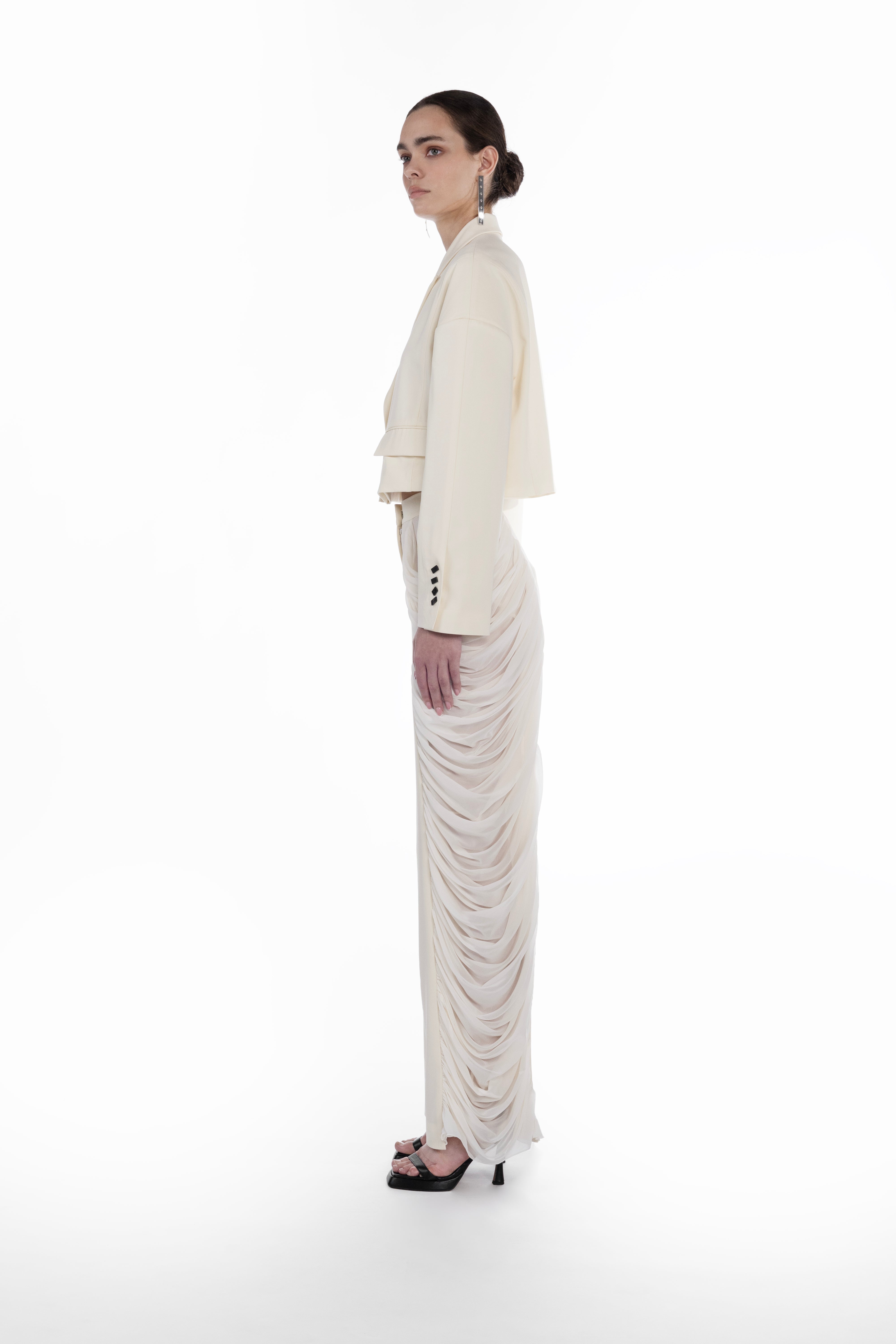 Silk Folds Trousers in Ivory, side view, sculptural tailored trousers with layered silk folds and fluid full-length drape and Falling Shoulders Jacket in light neutral virgin wool, side view, cropped silhouette with soft structured shoulders