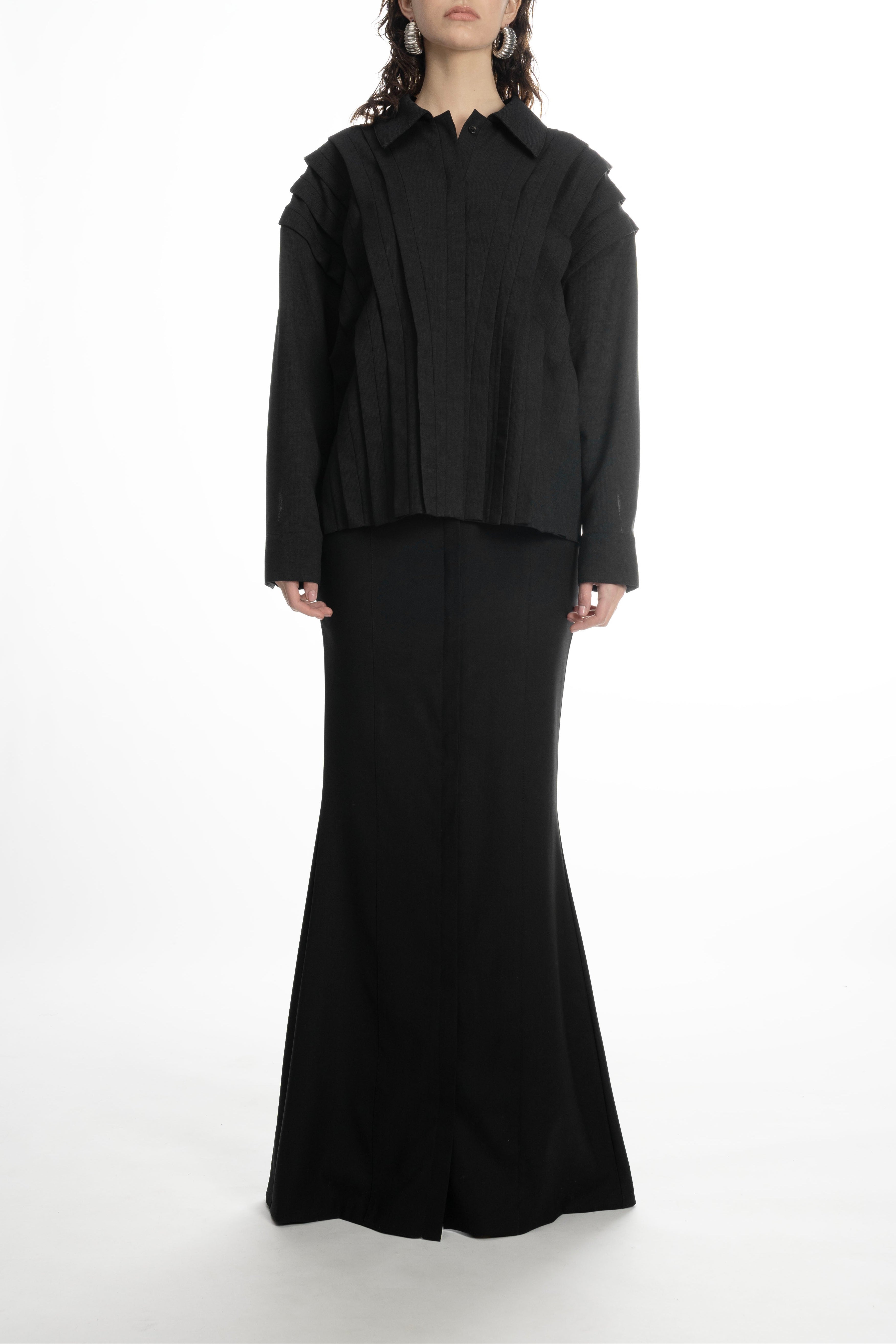 Woman wearing long black skirt and matching blouse