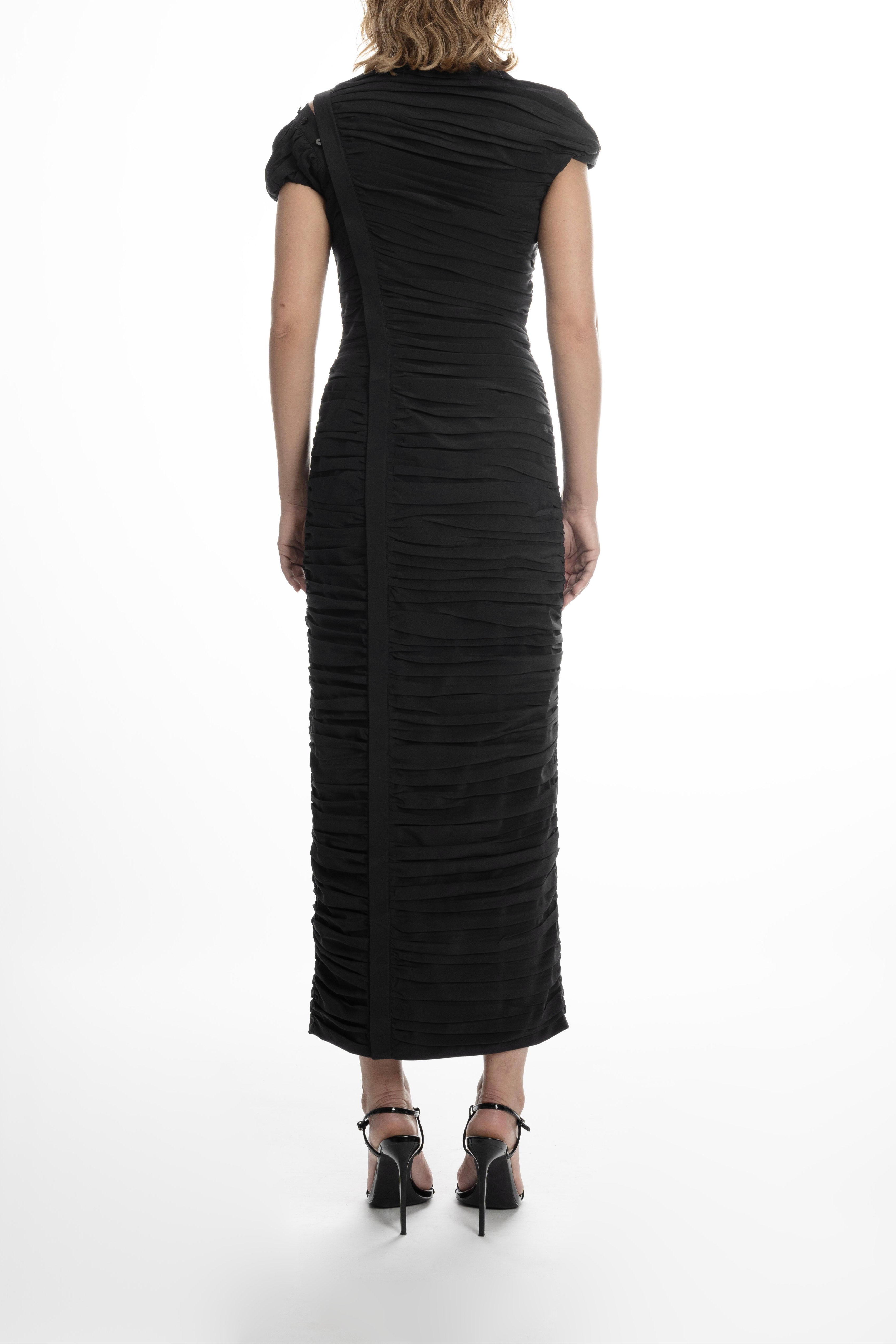 Back view of the black Pleated Dress highlighting the diagonal placket seam and continuous pleats