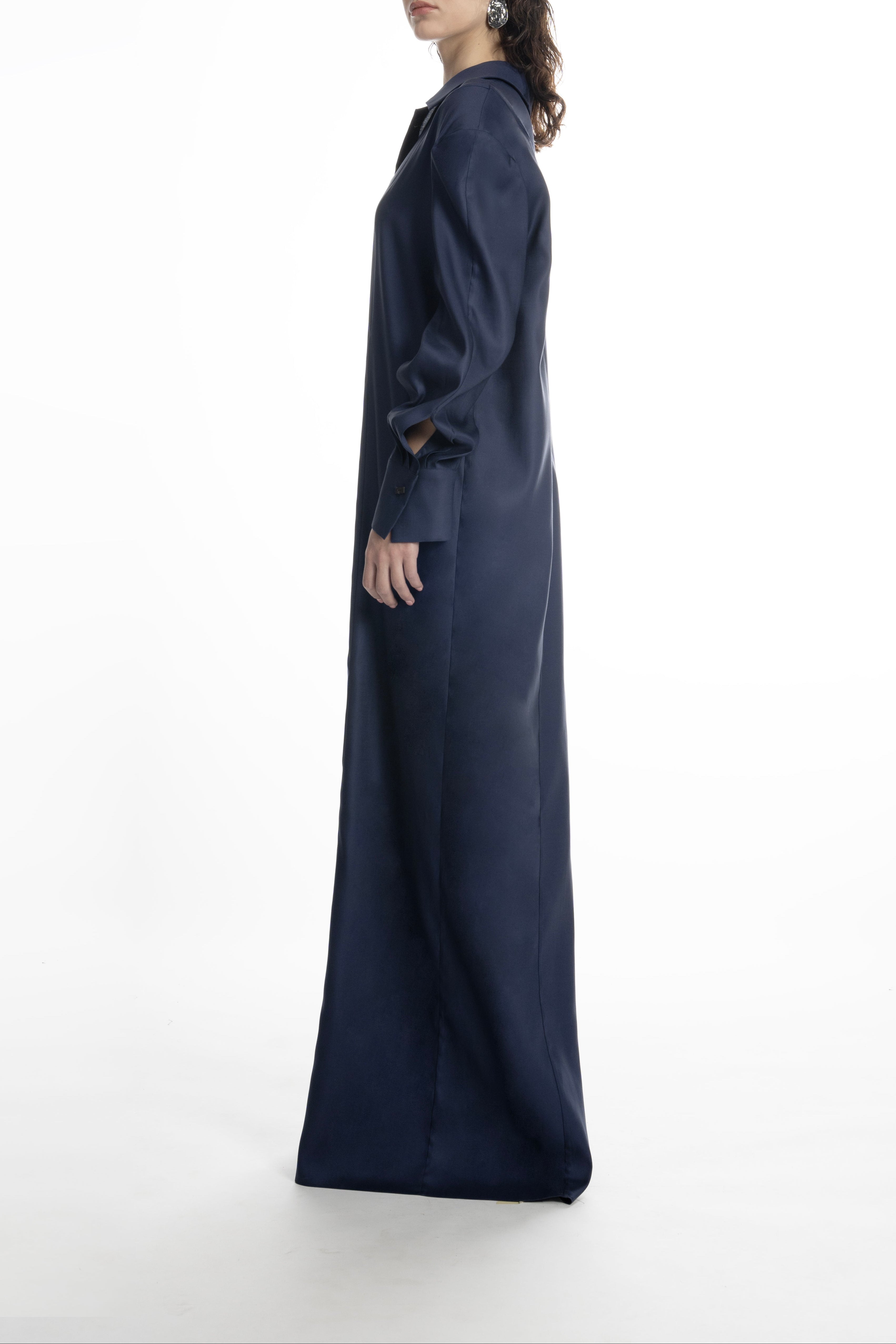 Dark Blue long shirt dress on model, side profile; fluid drape and architectural shoulder shaping, floor-length.