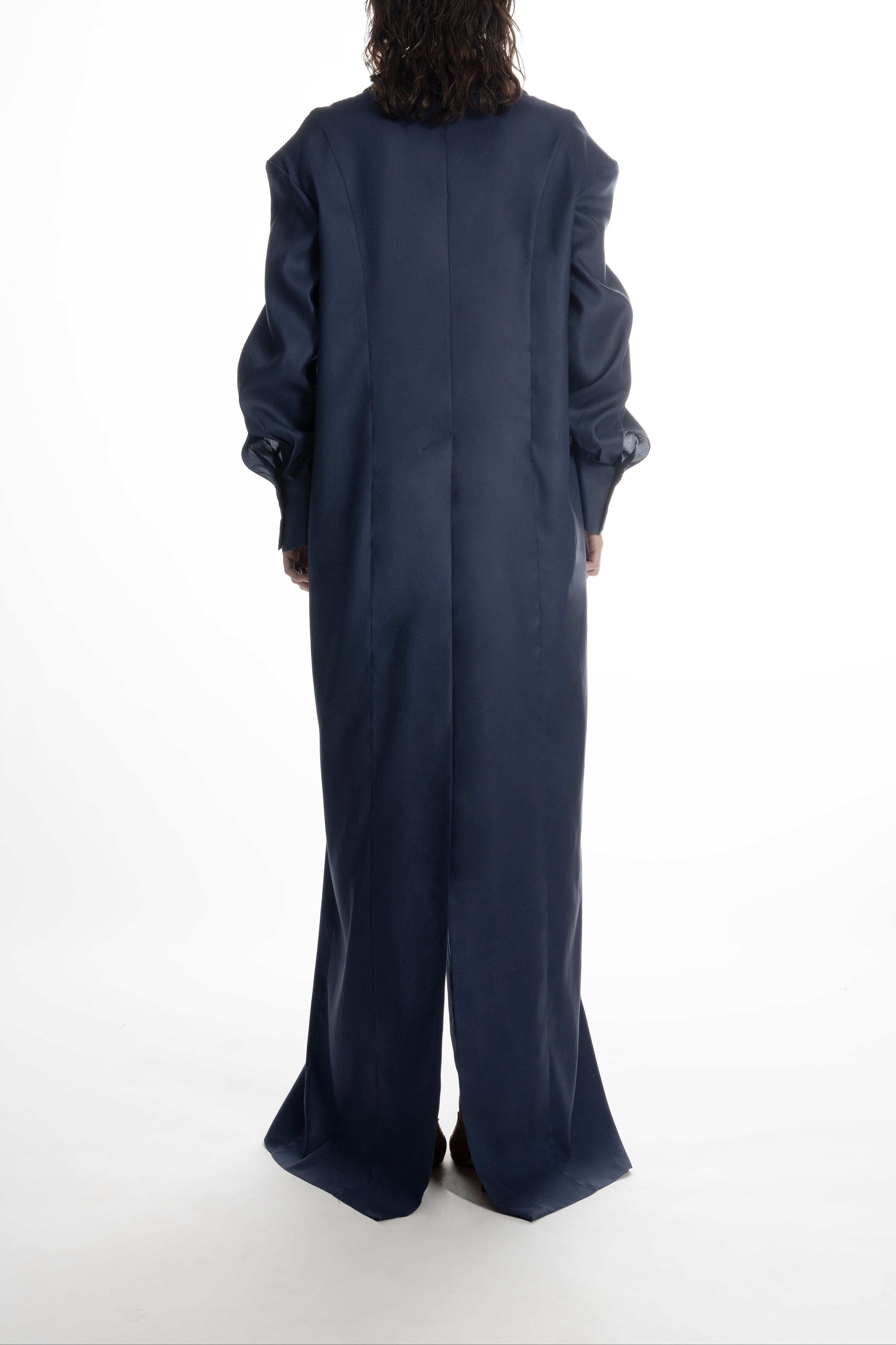 Dark Blue long shirt dress on model, back view; straight hem with vent, structured cuffs, elegant column silhouette.