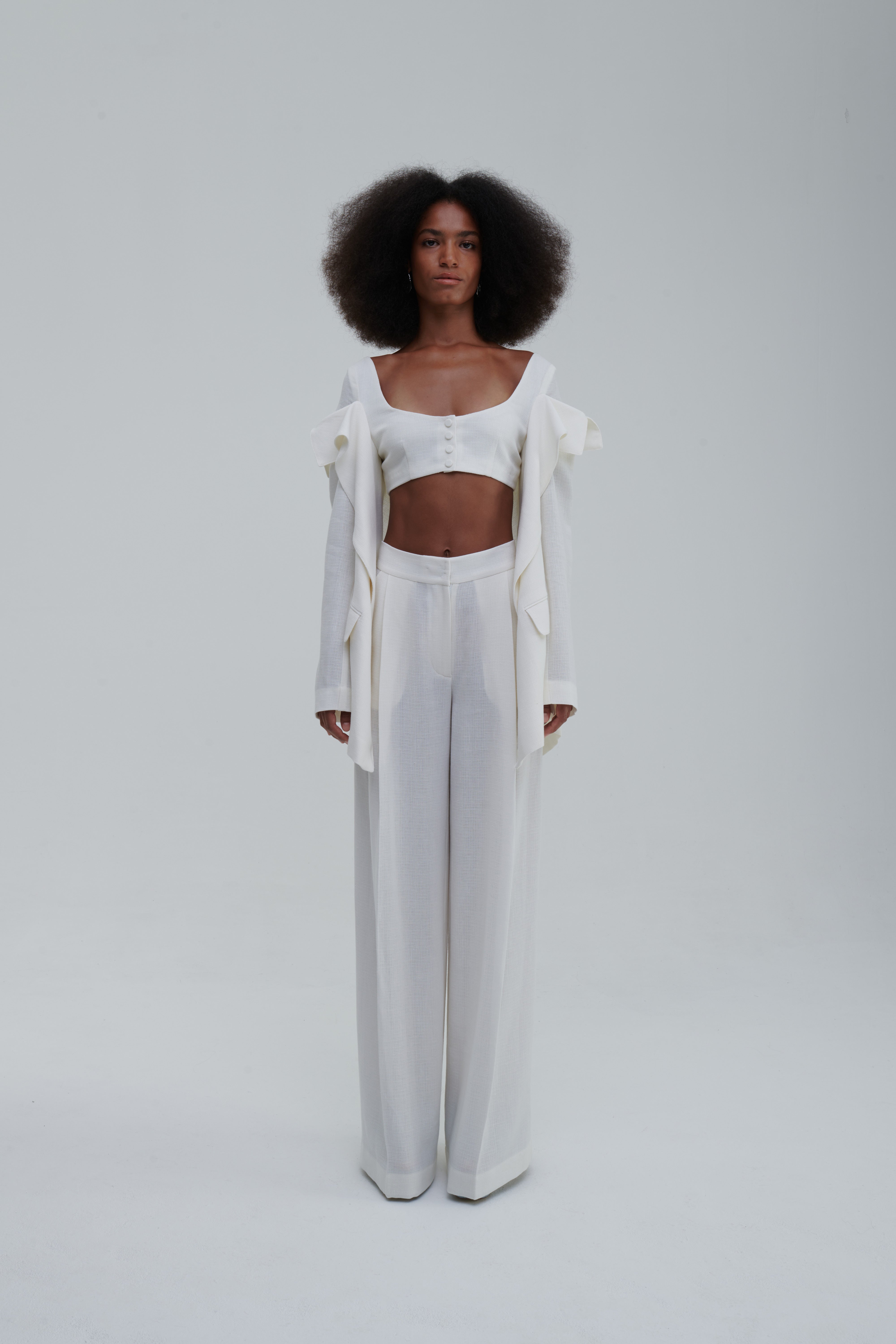 White falling-jacket crop top, front view, draped panels and covered buttons