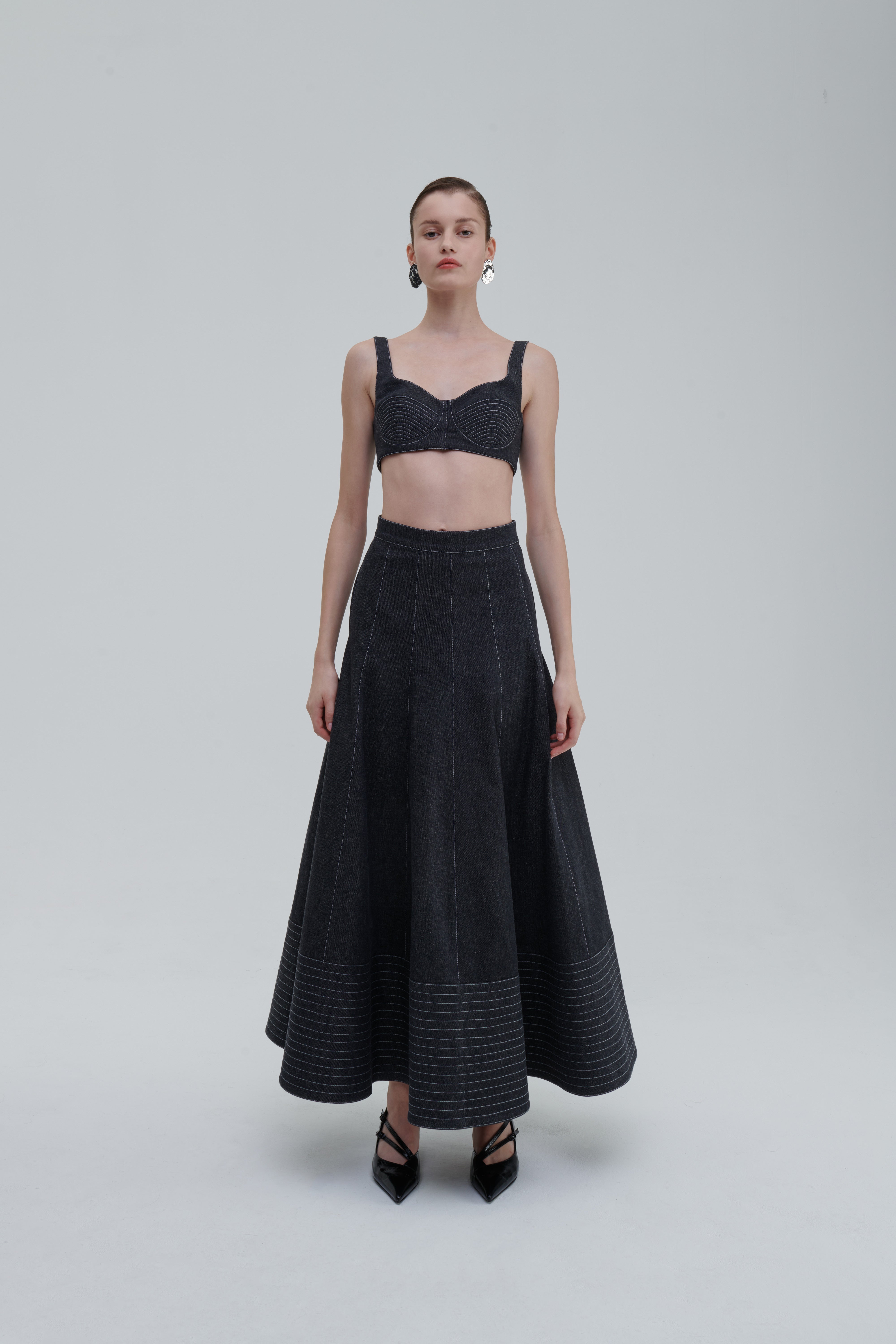 Anthracite quilted denim skirt on model, front view, flared hem
