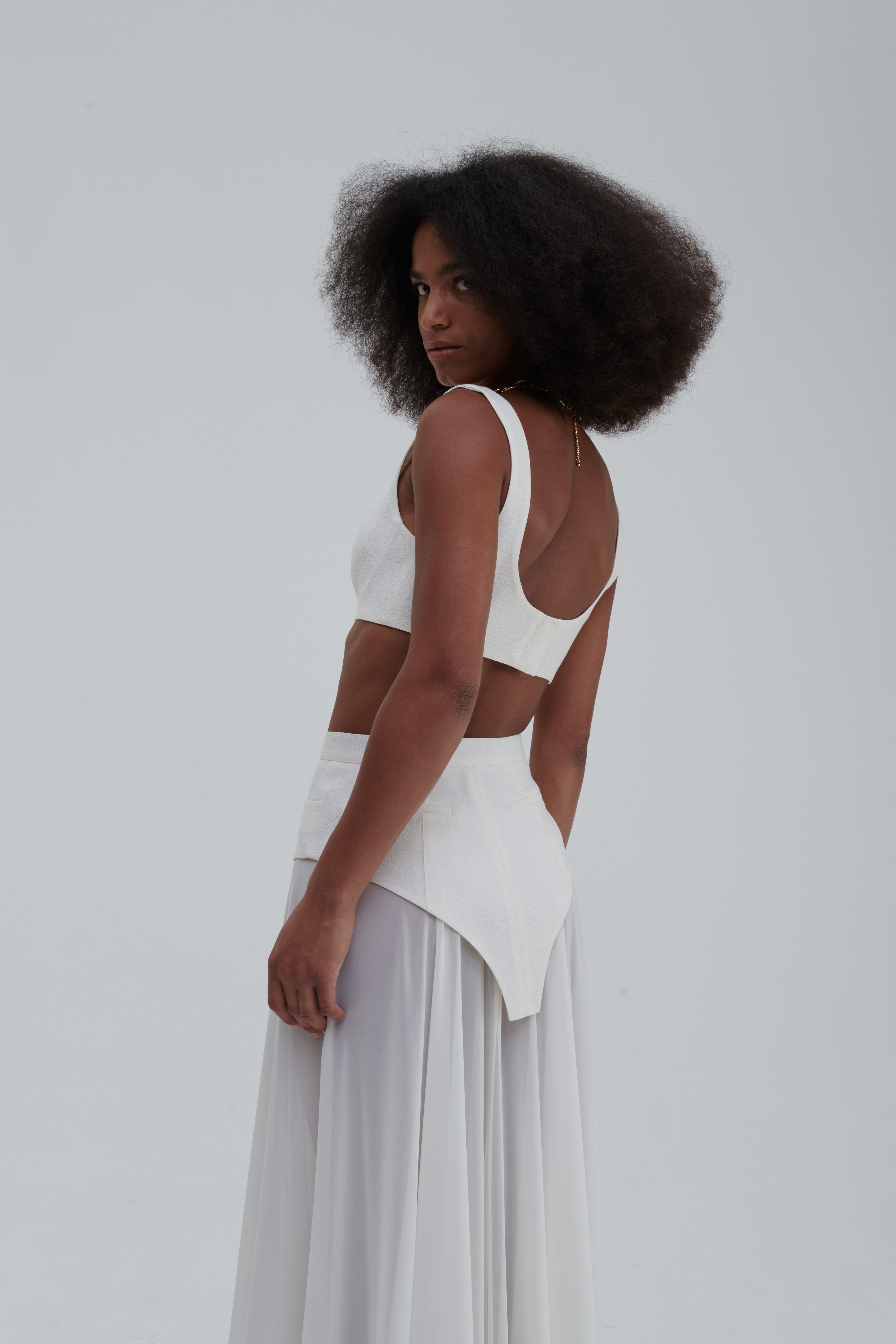 Silk bustier model pose, ivory, styled with skirt, side view