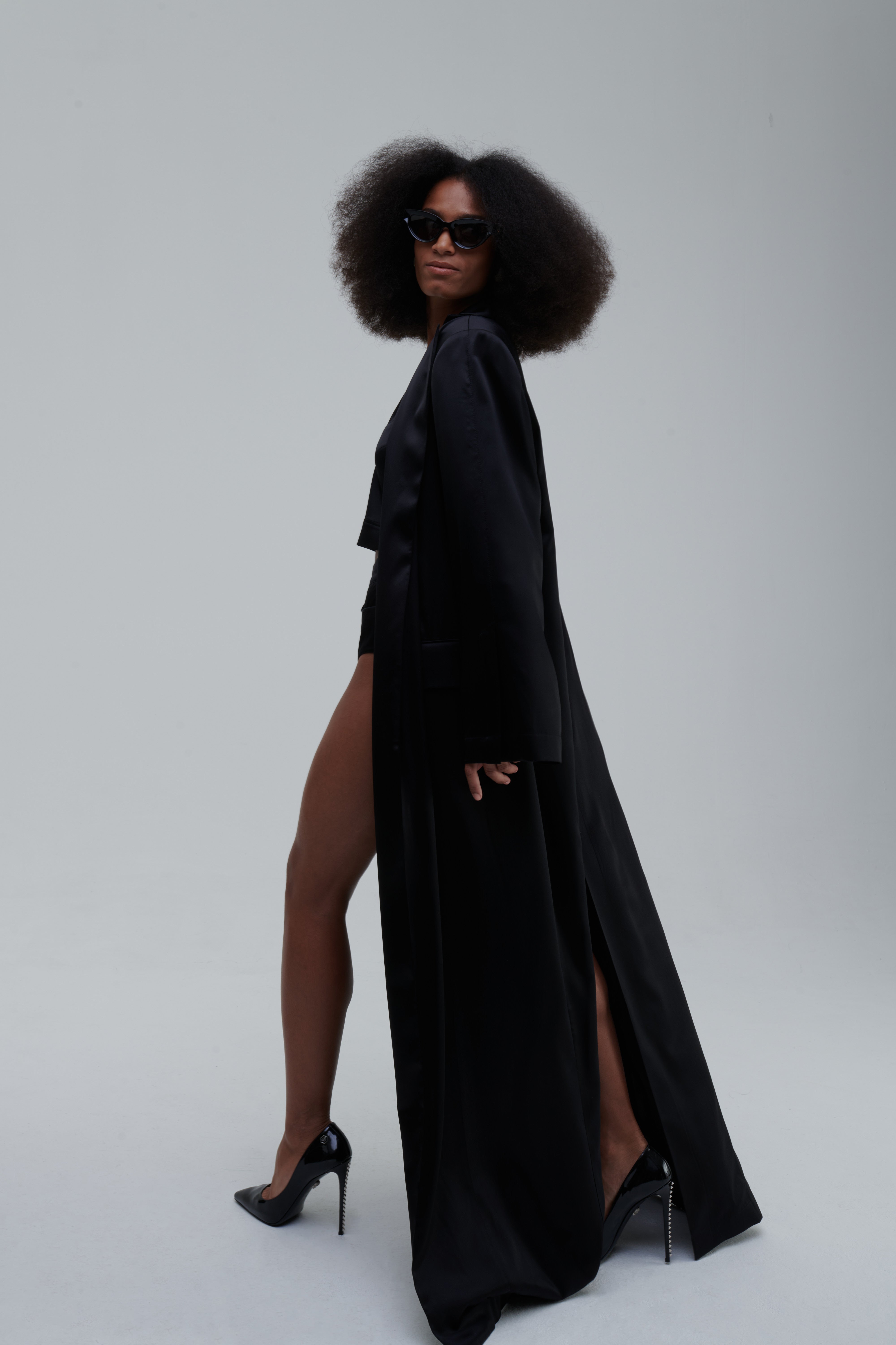 SILK LONG COAT by Sagio from the Spring/Summer 2025 collection — a full-length, flowing silk coat with a minimalist cut, subtle sheen, and relaxed tailored fit. Elegant and lightweight outerwear by thesagio.com