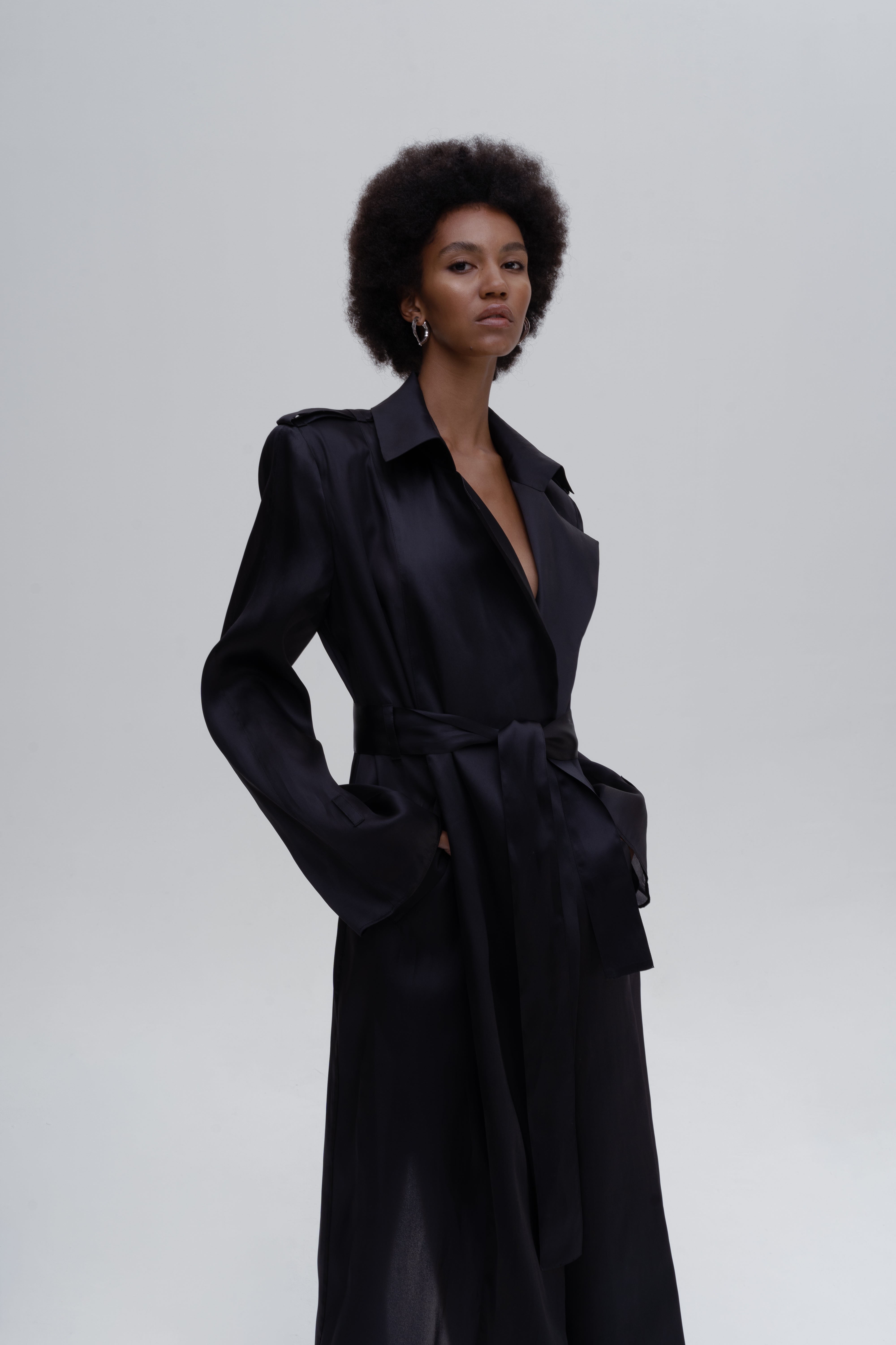 Women’s black silk trench coat with wide lapels and tie belt