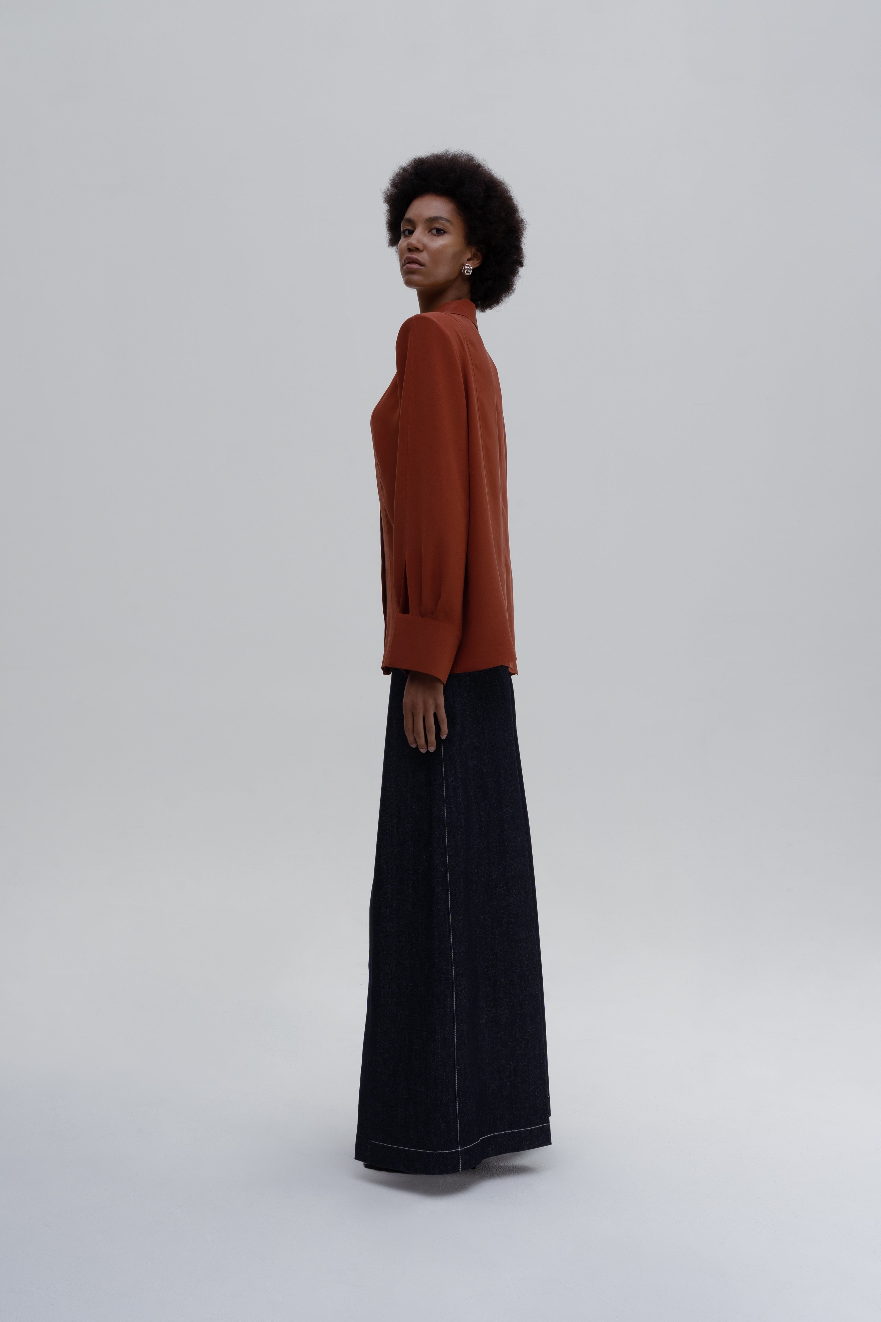 Silk Shirt by Sagio from the Spring/Summer 2025 collection, featuring a relaxed-fit, long-sleeve red silk blouse with a classic collar and concealed button placket. Luxury women's fashion by Sagio — discover more at thesagio.com.