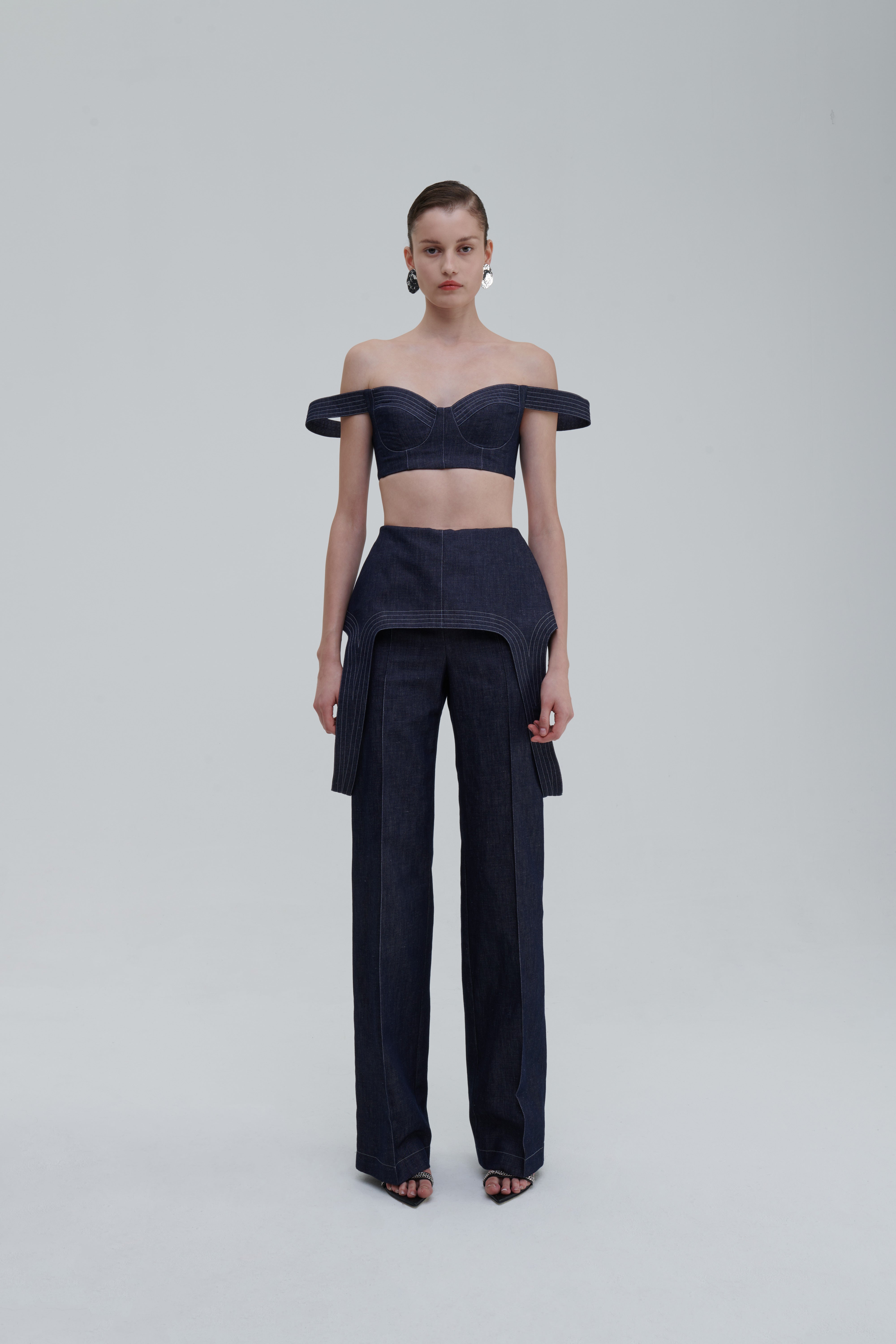 DENIM FALLING TROUSERS by Sagio from the Spring/Summer 2025 collection, showcasing high-waisted, wide-leg denim pants with a distinctive draped design and architectural silhouette. Premium contemporary fashion from thesagio.com.