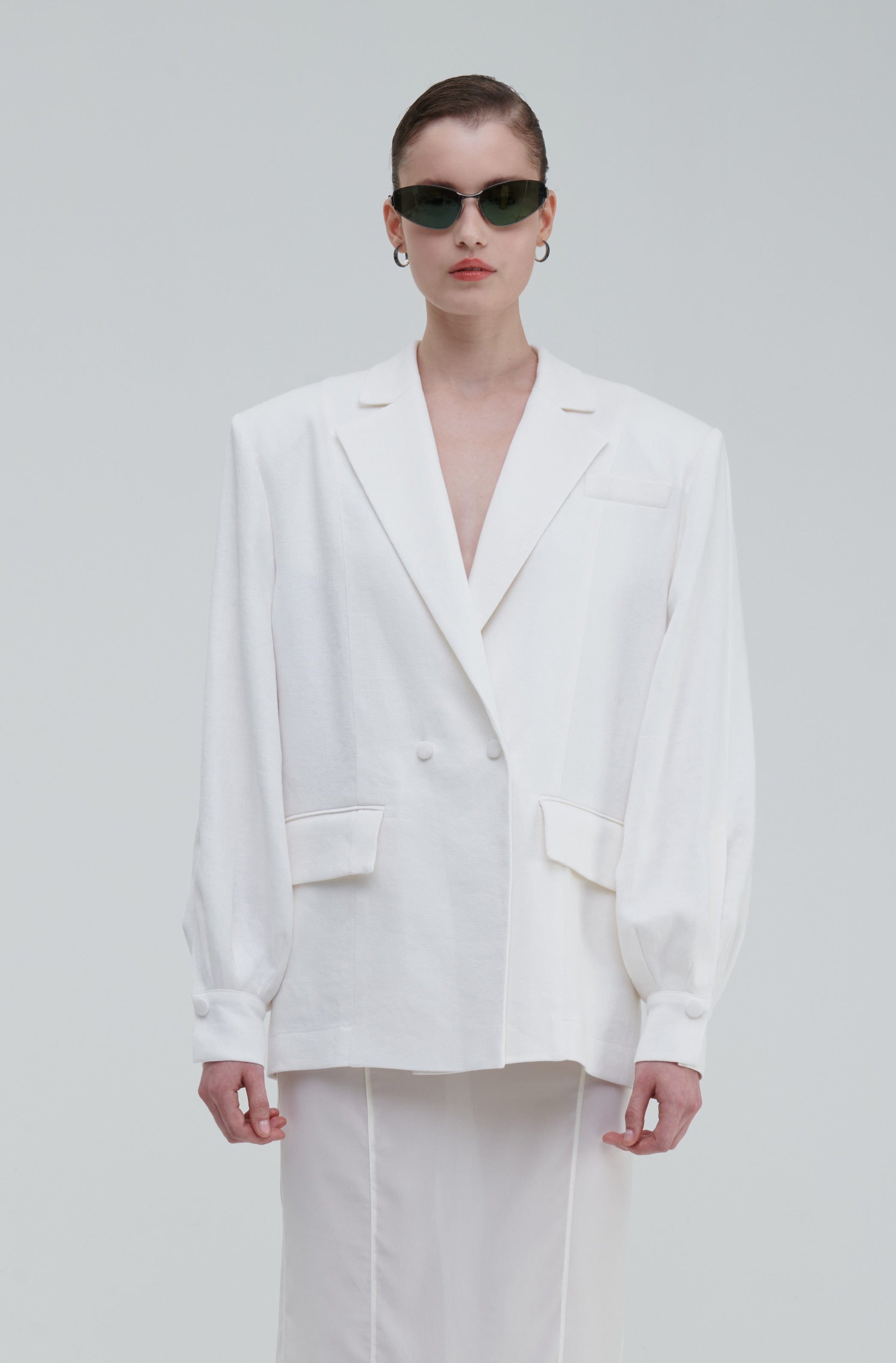 LINO DOUBLE-BREASTED BLAZER by Sagio from the Spring/Summer 2025 collection — a structured, double-breasted linen blazer in natural beige, featuring peak lapels, front pockets, and a refined minimalist silhouette. Discover elevated tailoring at thesagio.com