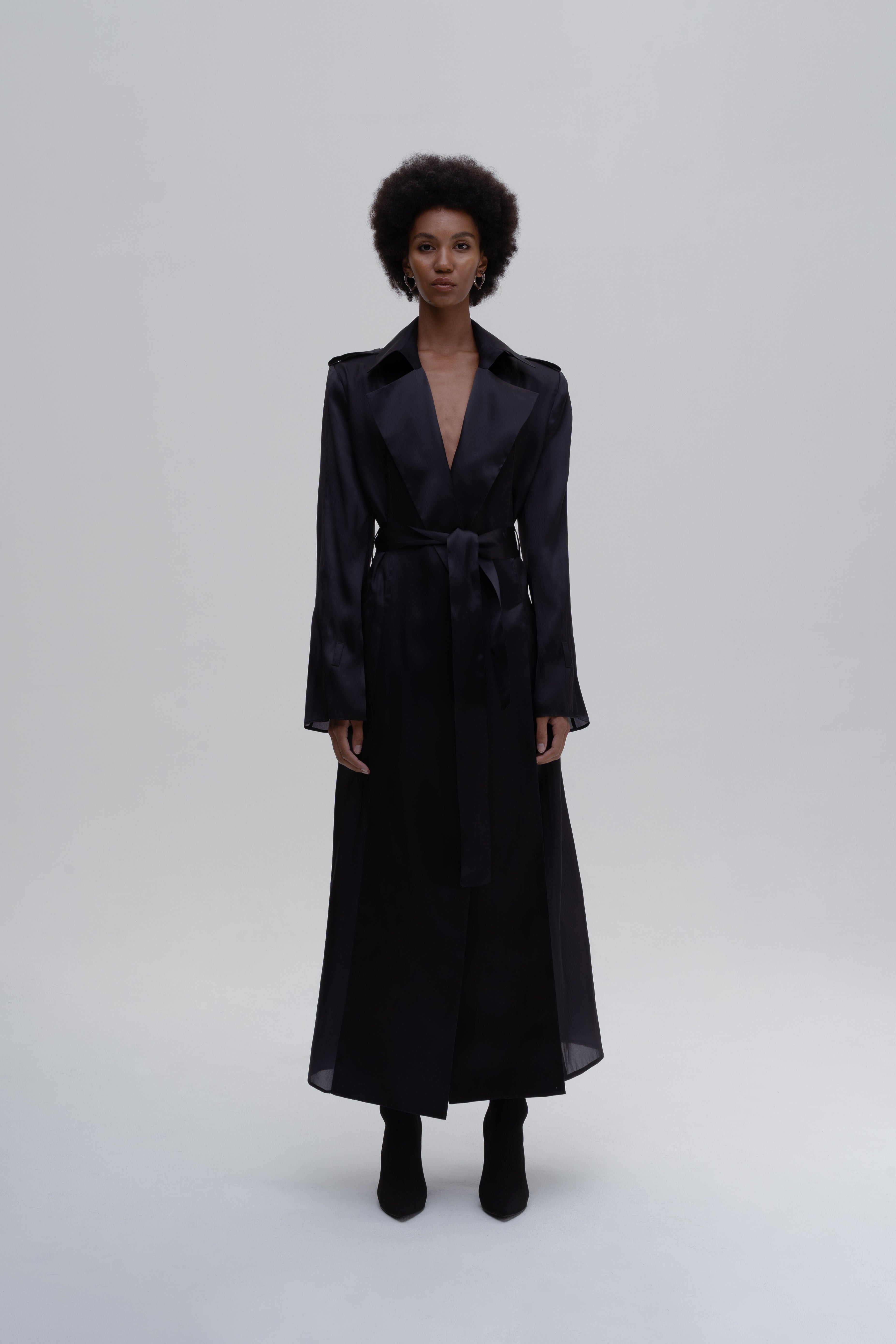 Model wearing the SILK SLITS TRENCH COAT by Sagio from the Spring/Summer 2025 collection — a lightweight, fluid trench coat crafted from soft silk, featuring high side slits, a relaxed silhouette, and a modern minimalist design. Explore the full look at thesagio.com