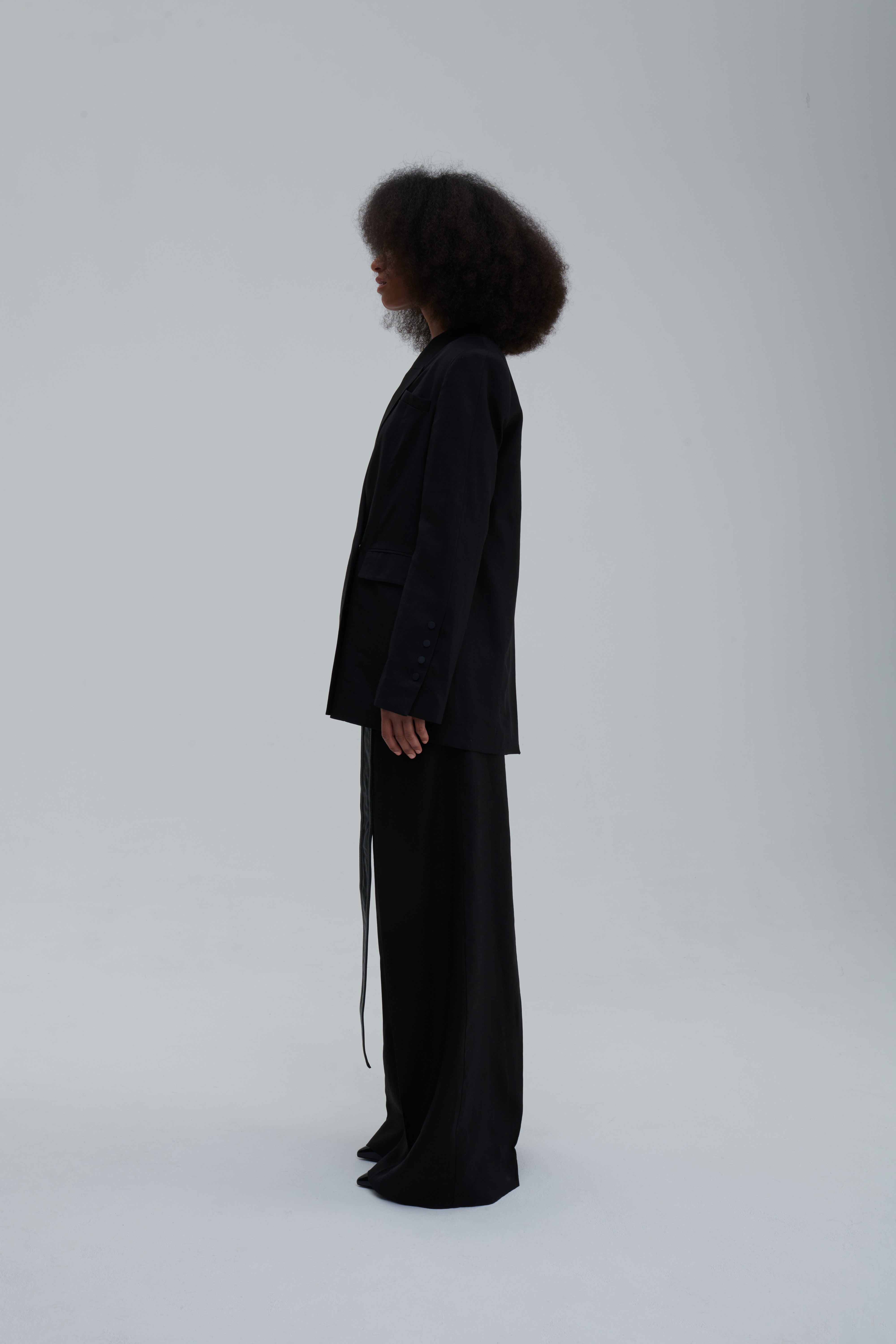 Black wide-leg trousers, side view with long belt strap
