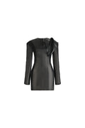 A black faux-leather mini dress with long sleeves, a split V-neckline, and a dramatic oversized bow detail on the right shoulder, shown against a plain white background.