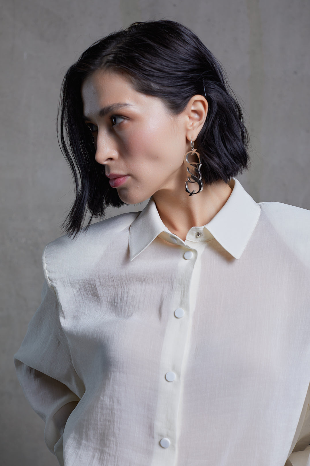 Close-up of buttoned white wool blouse showing collar details and fabric texture