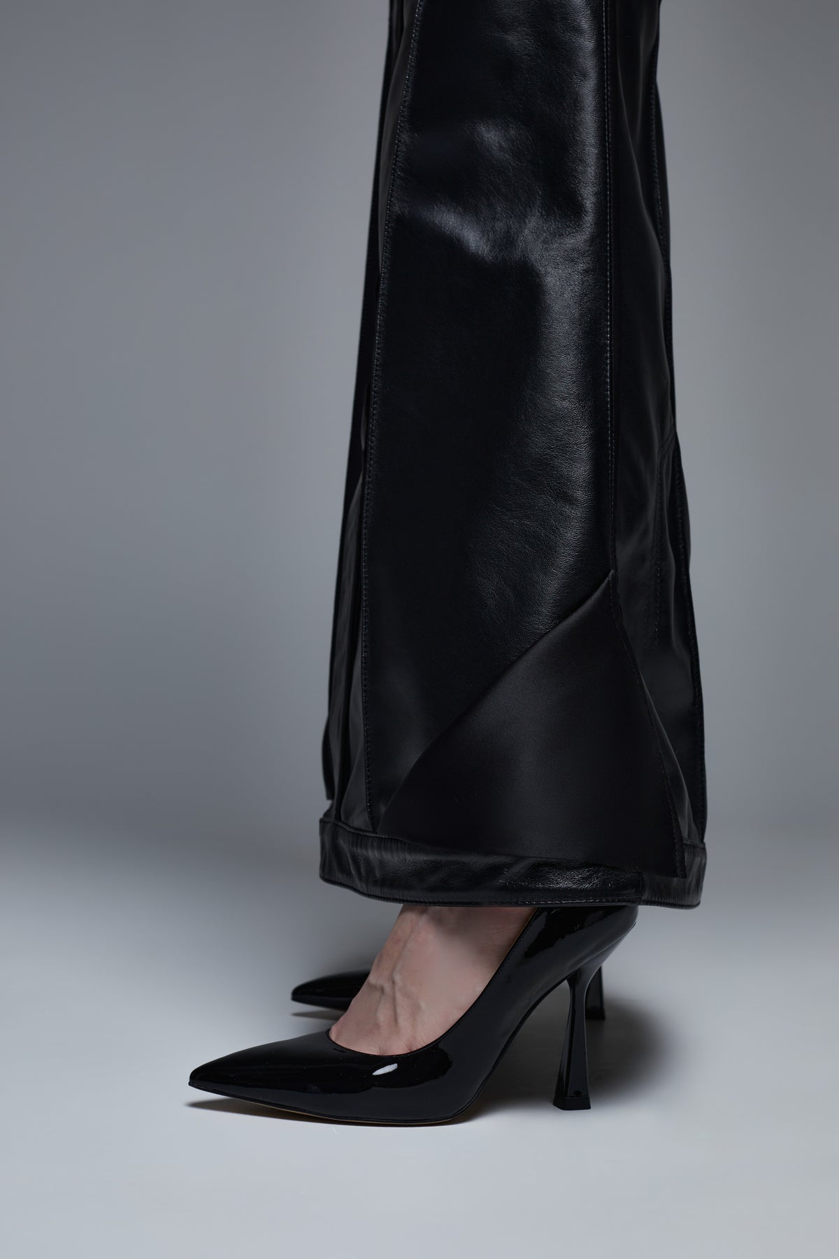 Black leather maxi skirt hem detail close-up with slight flared finish