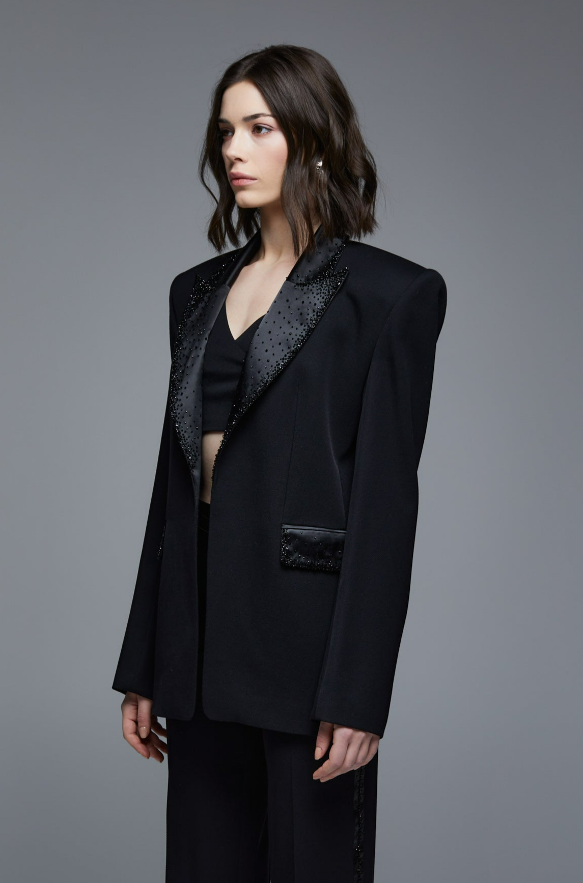 Black embellished tuxedo blazer three-quarter side view on model