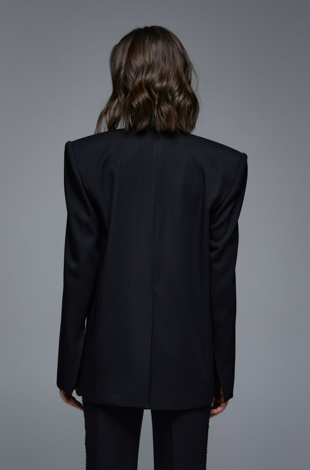 Black tailored tuxedo blazer back view on model with structured shoulders