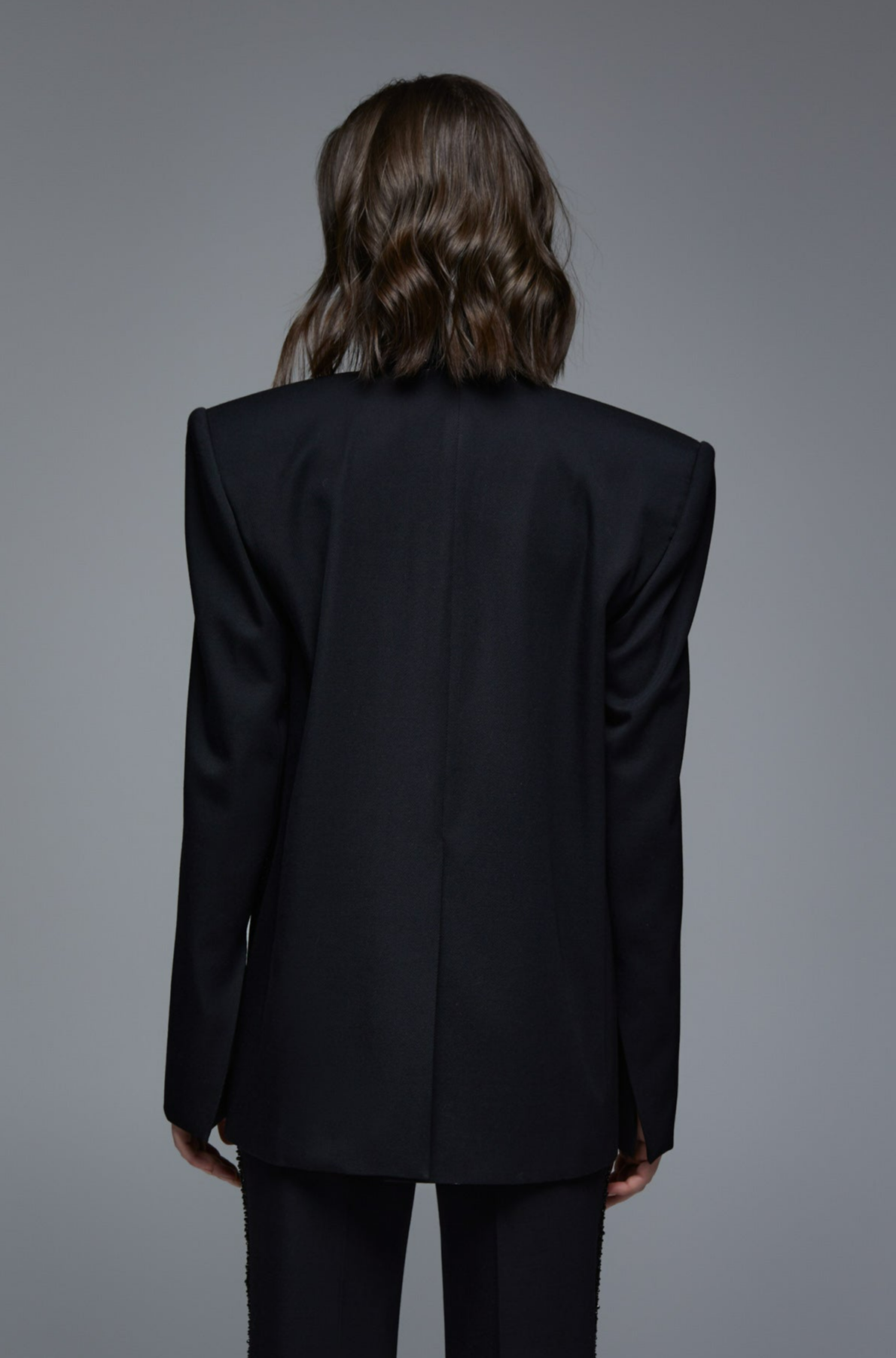 Black tailored tuxedo blazer back view on model with structured shoulders