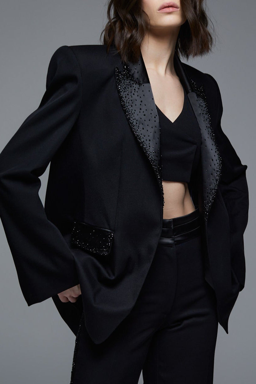 Black designer tuxedo blazer close-up with crystal embroidered lapels and pockets