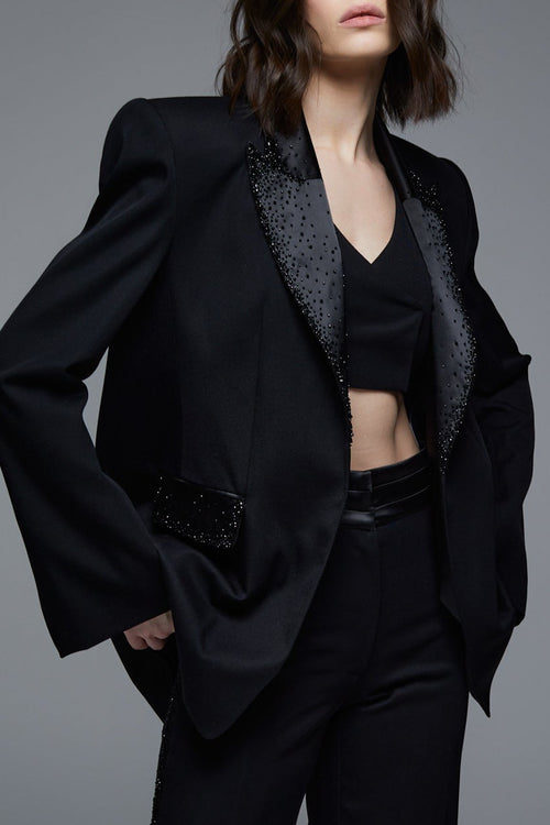 Black designer tuxedo blazer close-up with crystal embroidered lapels and pockets