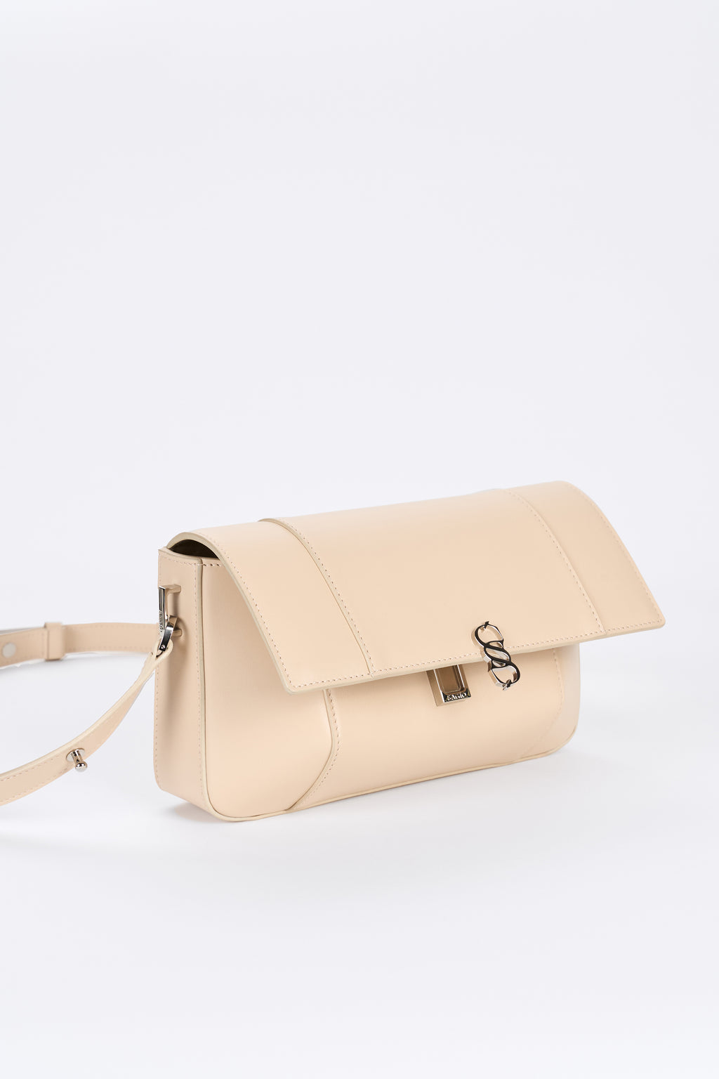 Beige leather bag detail with flap closure and silver-tone hardware