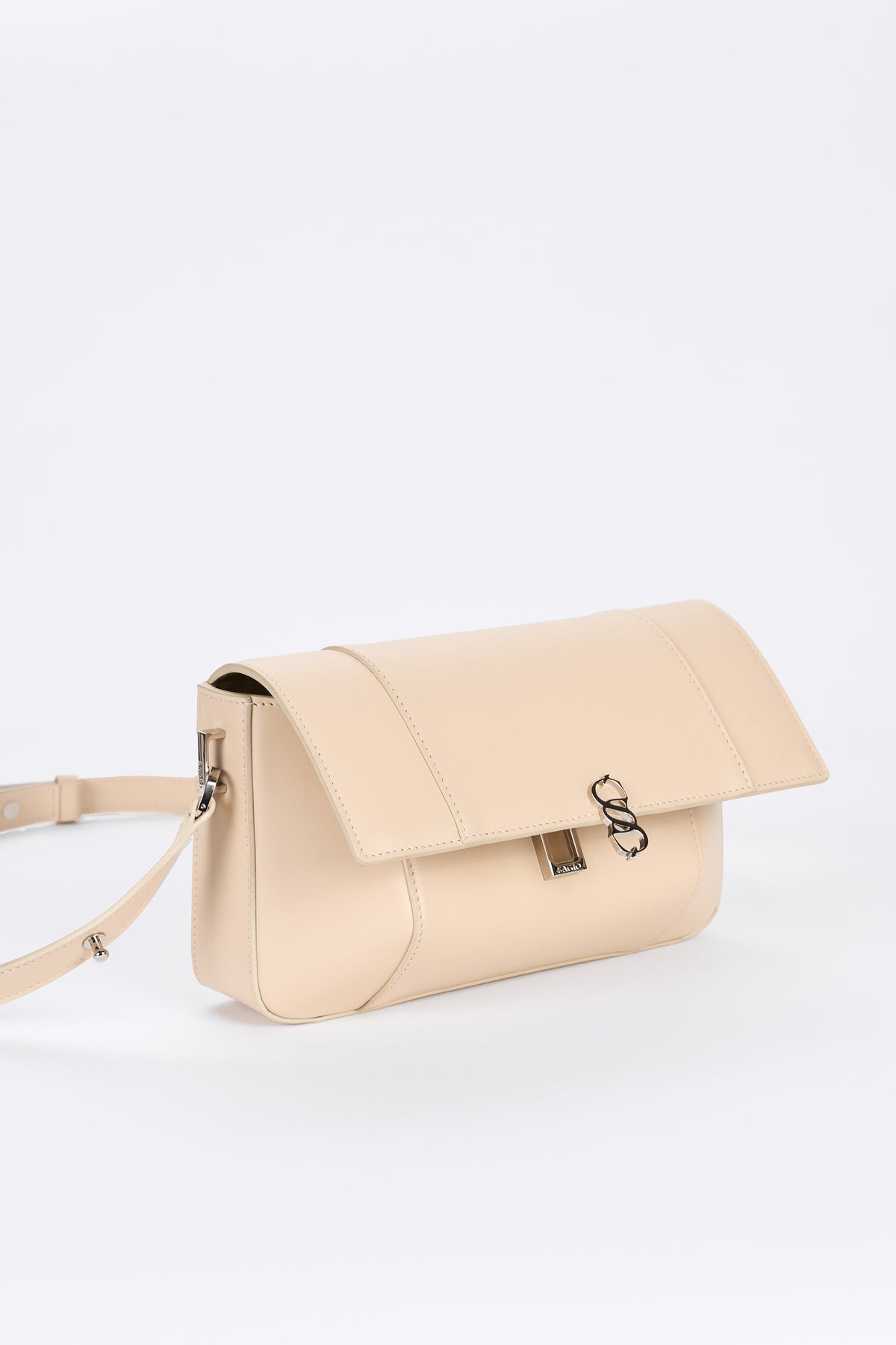 Beige leather bag detail with flap closure and silver-tone hardware