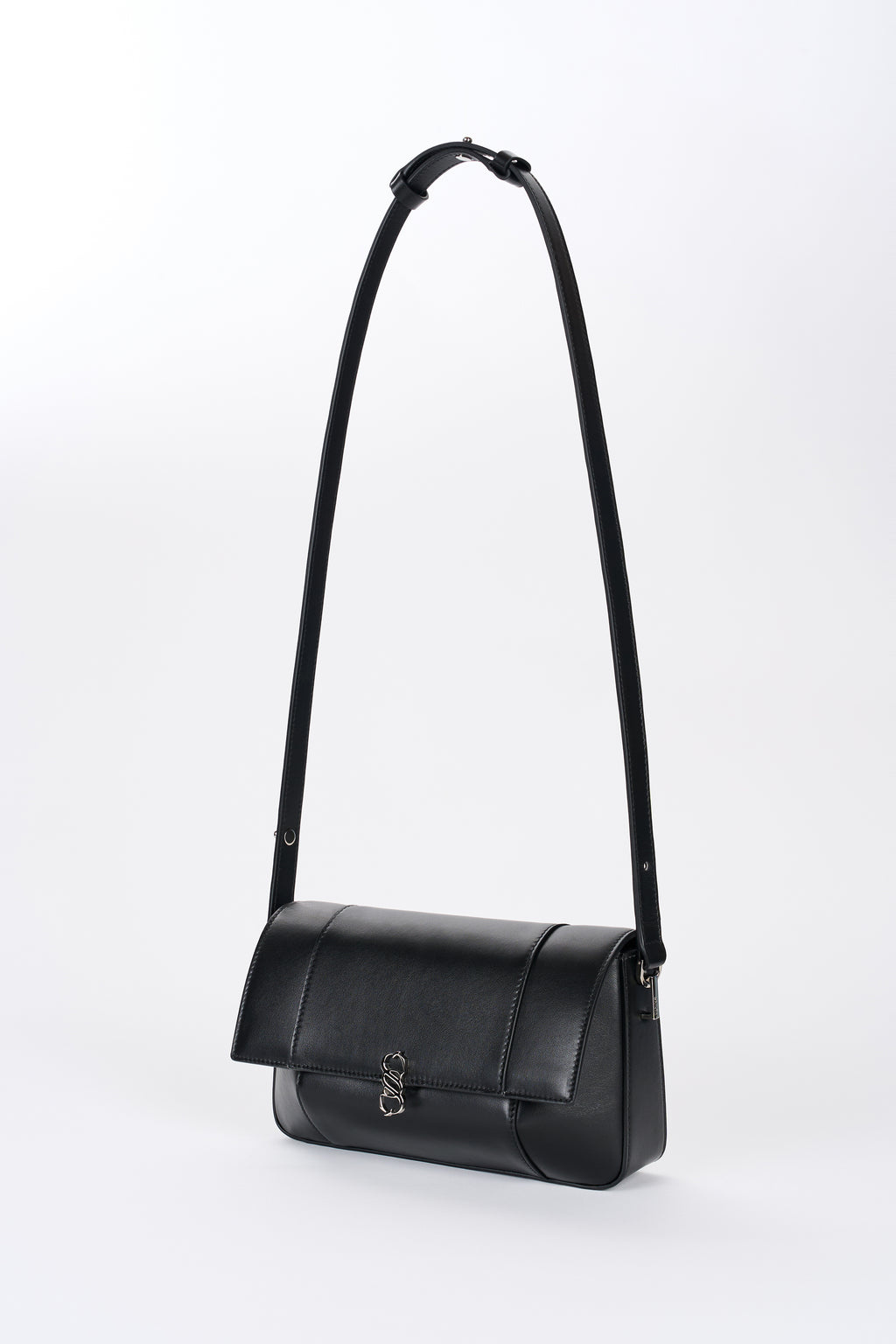 Black Il Cupola bag angled front view with elongated strap and curved flap