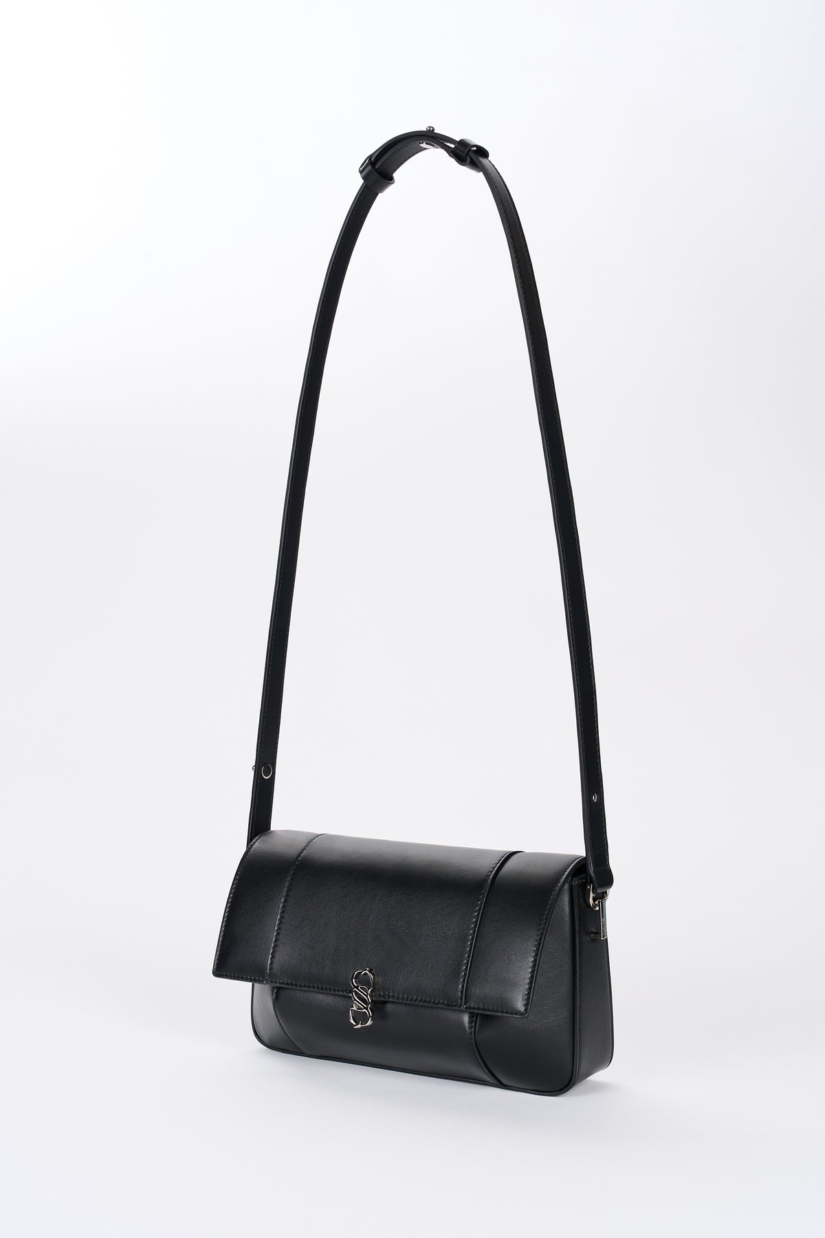 Black Il Cupola bag angled front view with elongated strap and curved flap