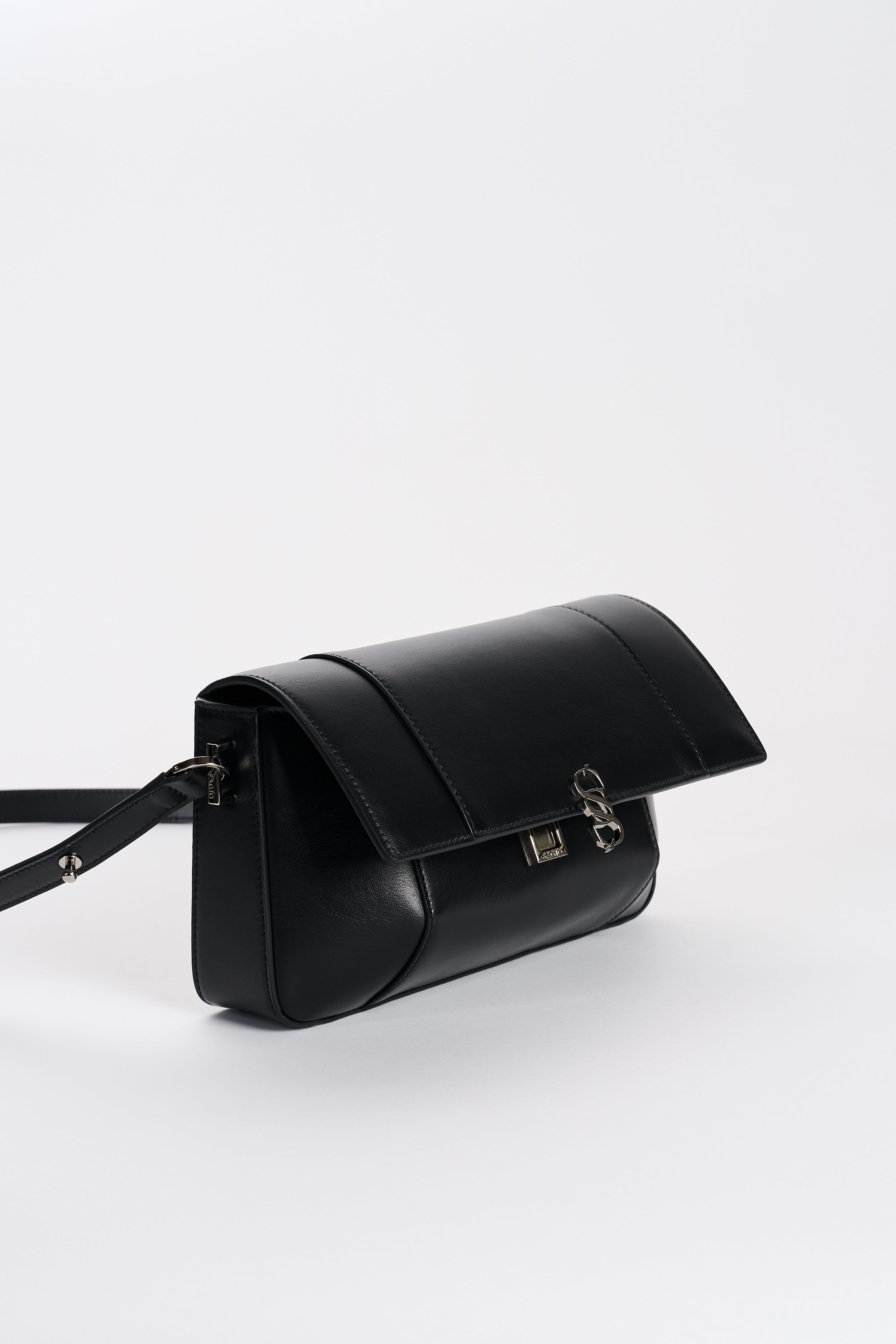 Black leather bag detail with flap closure and silver-tone logo hardware