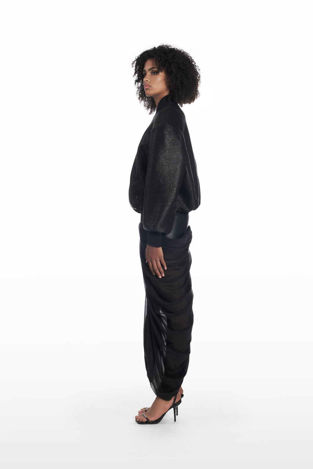 Oversize Raffia Bomber in black, side view with rounded volume and tactile raffia texture