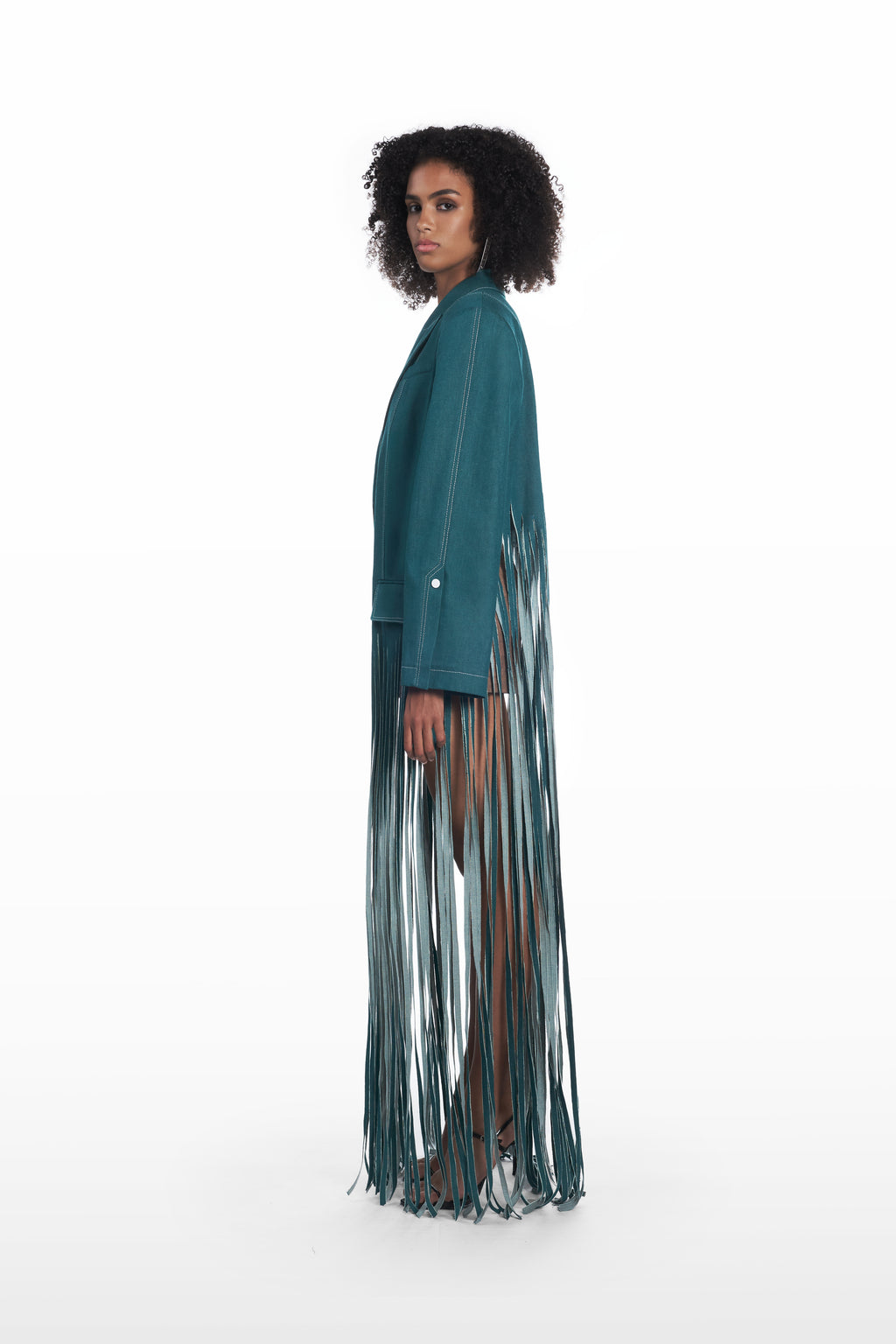 Oversize fringe denim coat in teal, side view with elongated fringe detailing and structured shoulders