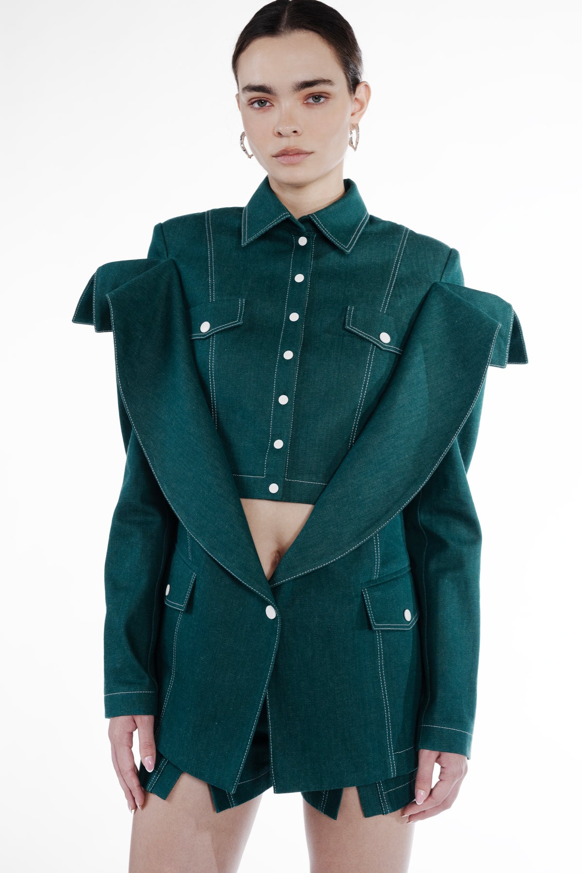 Short Falling Jacket in emerald green cotton, close-up front view, falling shoulder construction, contrast topstitching, and flap pockets