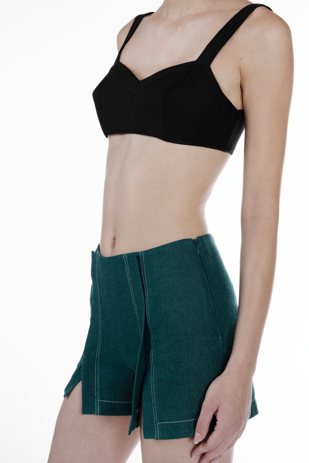 Mini Slits Shorts in Emerald Green, close-up detail view, luxury cotton mini shorts with front slit panels, visible topstitching and precise tailored finish