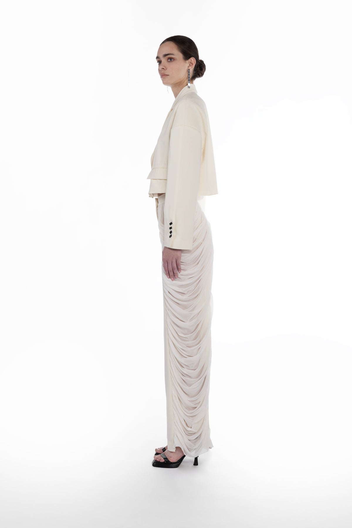 Silk Folds Trousers in Ivory, side view, sculptural tailored trousers with layered silk folds and fluid full-length drape and Falling Shoulders Jacket in light neutral virgin wool, side view, cropped silhouette with soft structured shoulders