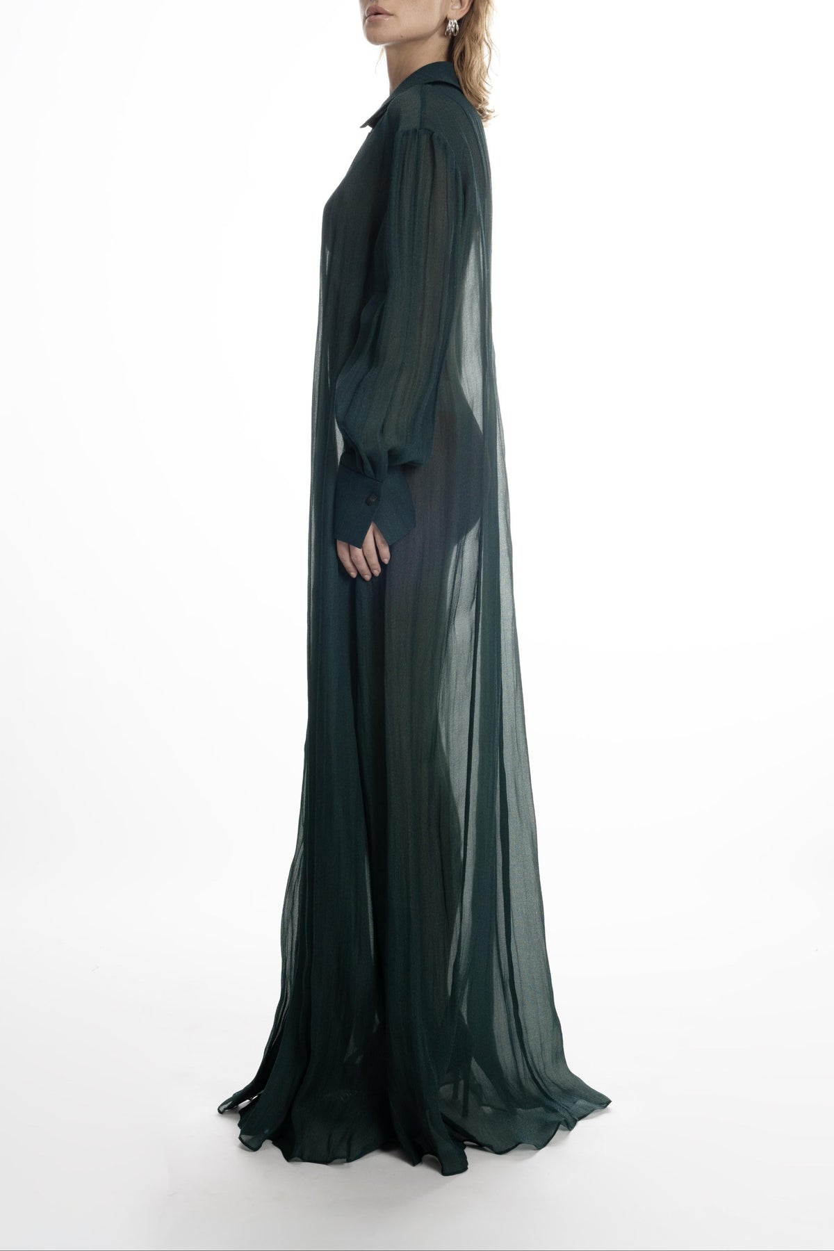 Deep green silk long shirt dress with long cuffs and fluid, semi-sheer drape. Side view 