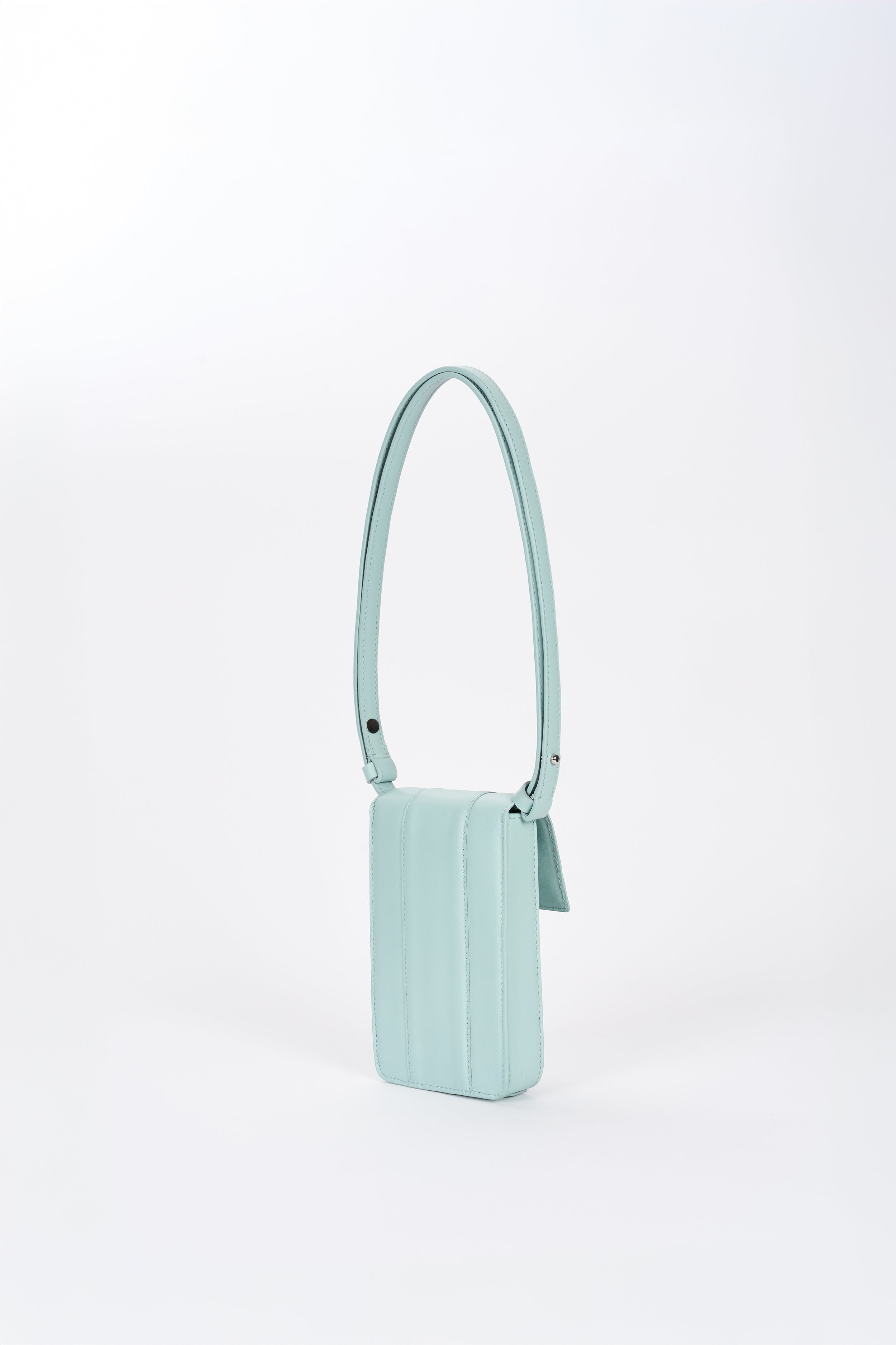 Clear aqua Il Cupolina leather bag side view with elongated strap and structured body