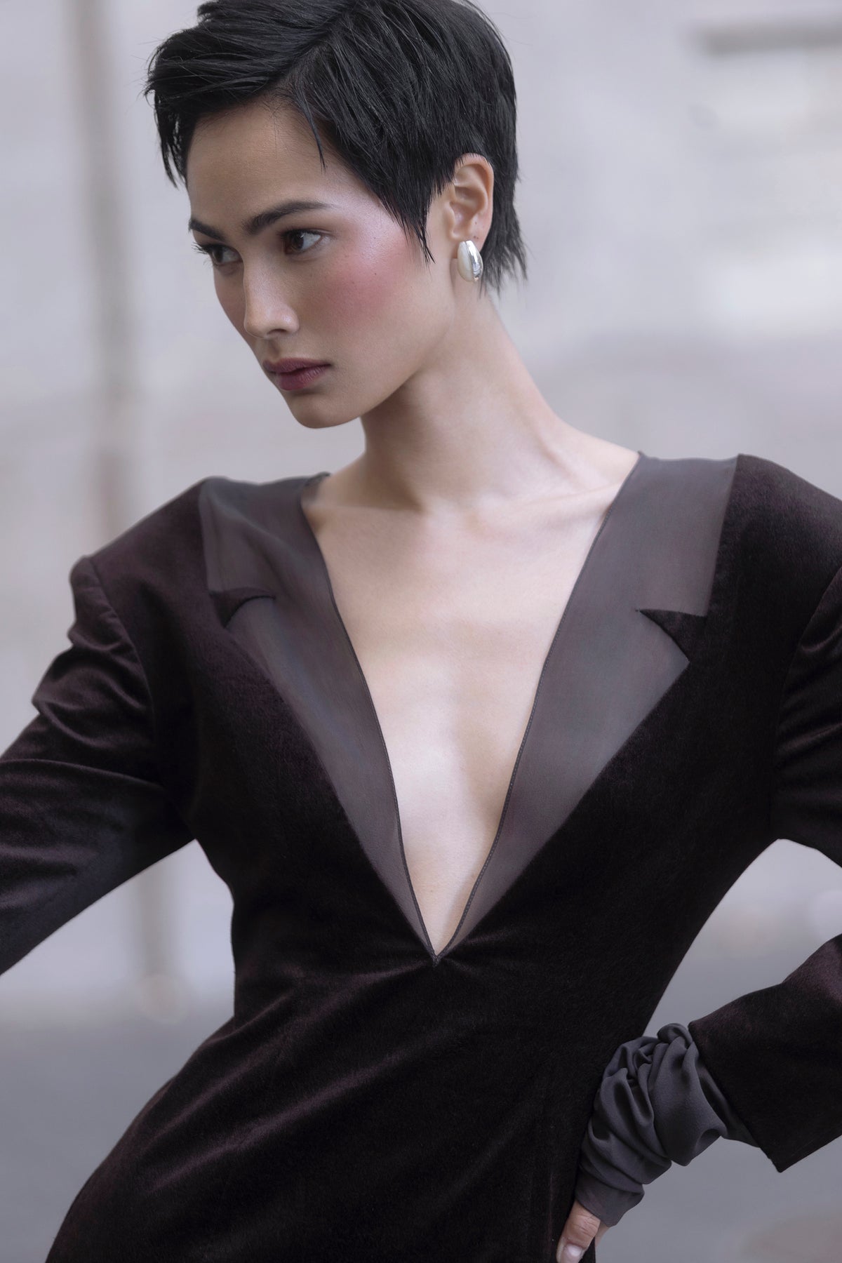 Close-up front view showing deep V silk-trim neckline and structured shoulders, brown long dress