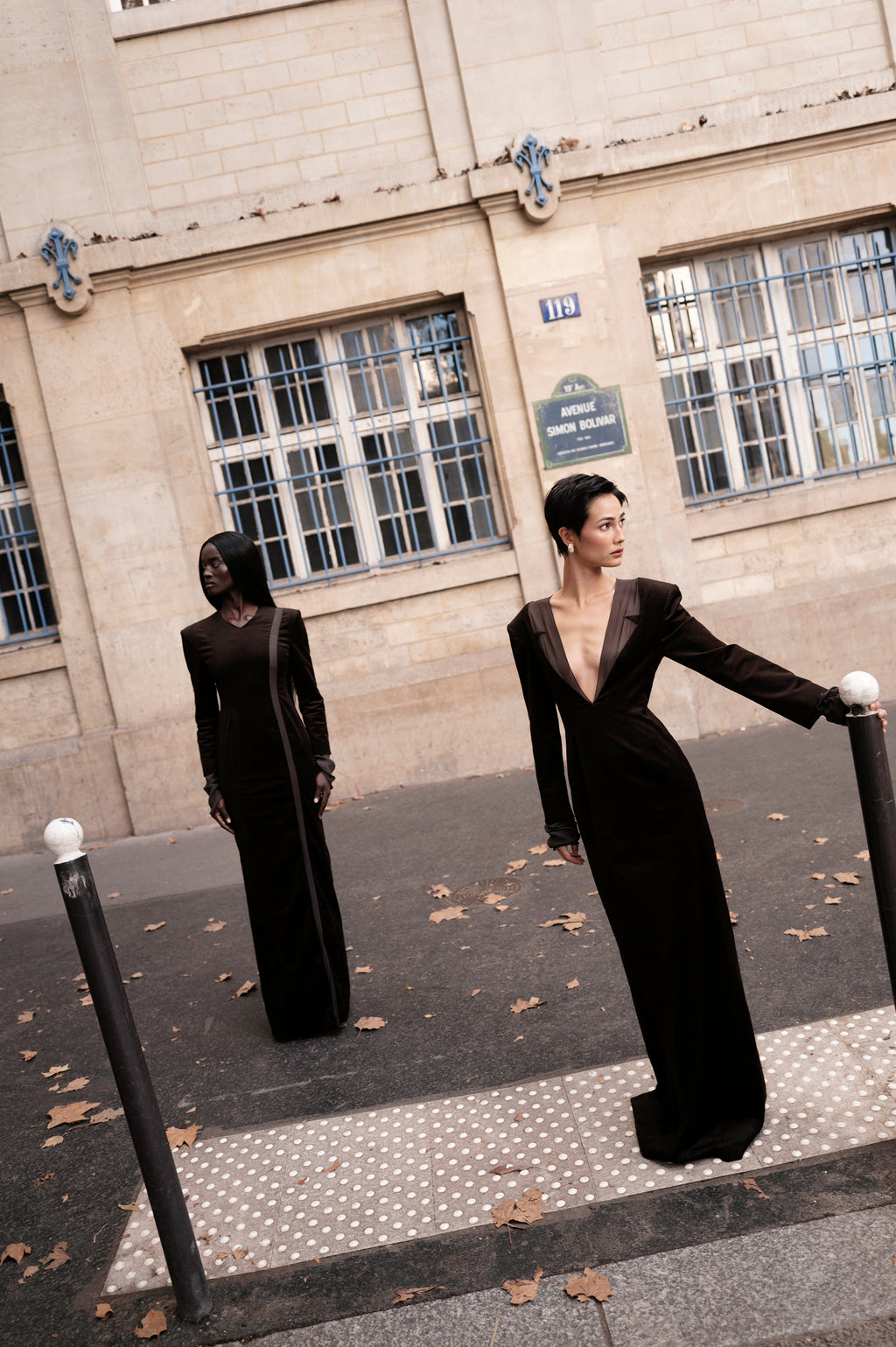 Two-model scene, Whitney long dress styled outdoors highlighting deep V and shoulder line